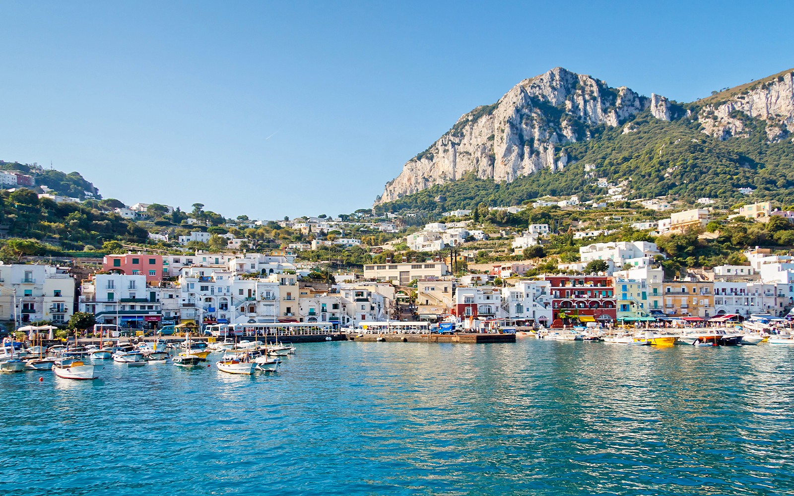 船只停靠在卡普里岛的大码头，周围是山坡建筑，这是真正罗马到庞培和索伦托一日游的一部分。