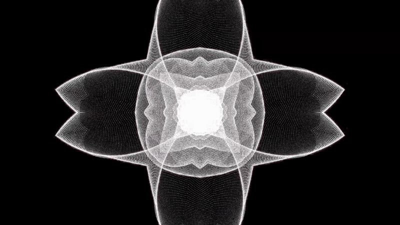 Person wearing black clothing carrying a black tote bag with a green globe-like geometric symbol, standing against a concrete wall in sunlight and shadow.