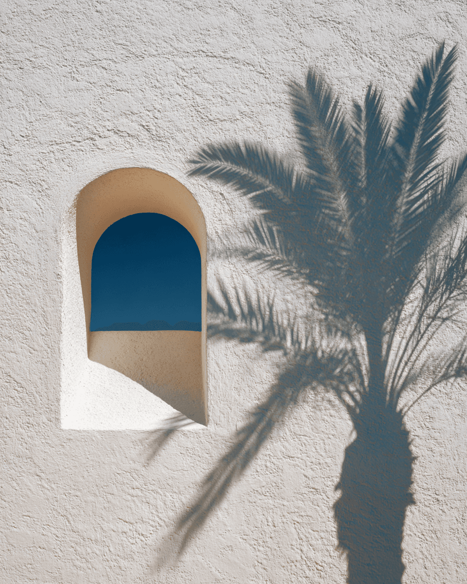 Smiling young woman with long hair standing against a dark green background, holding a finger to her chin.