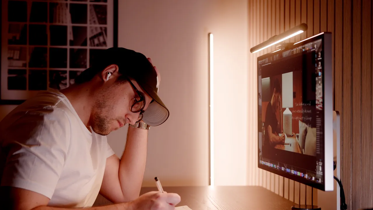 a guy writing in a notebook sitting at a desk