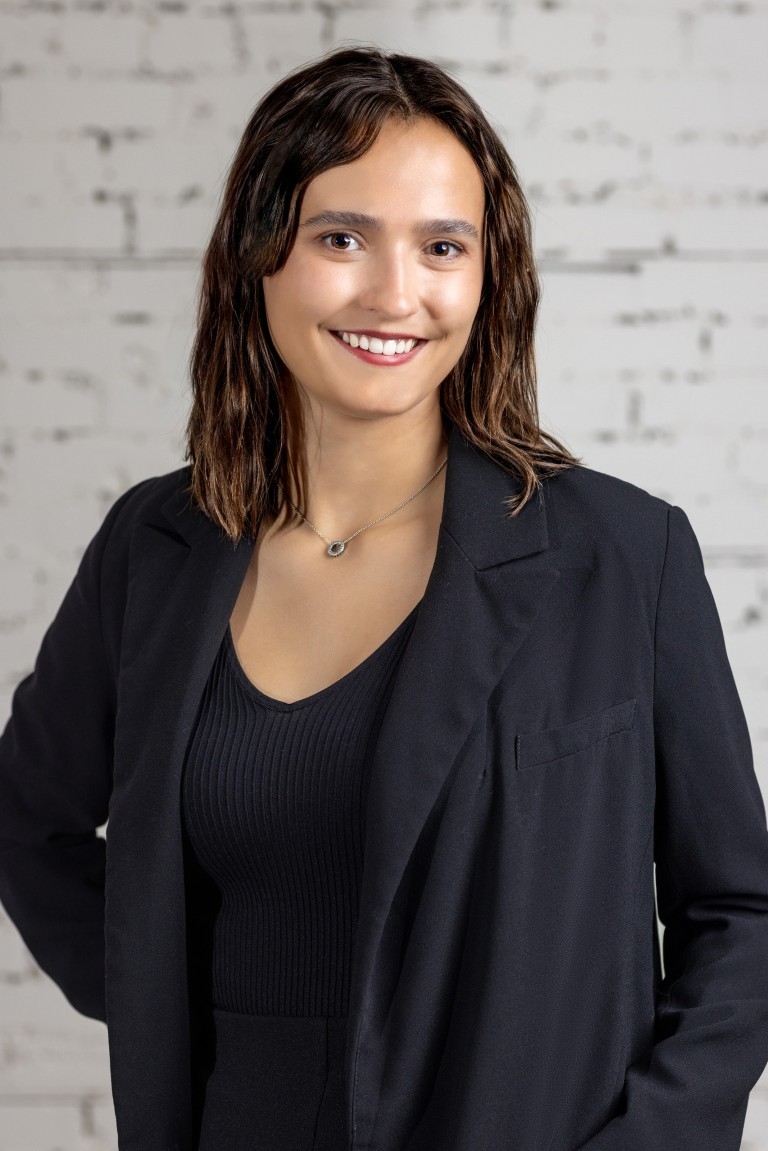 Image of Woman standing confidently in front of brick wall, representing KHD Homes' design and construction expertise.