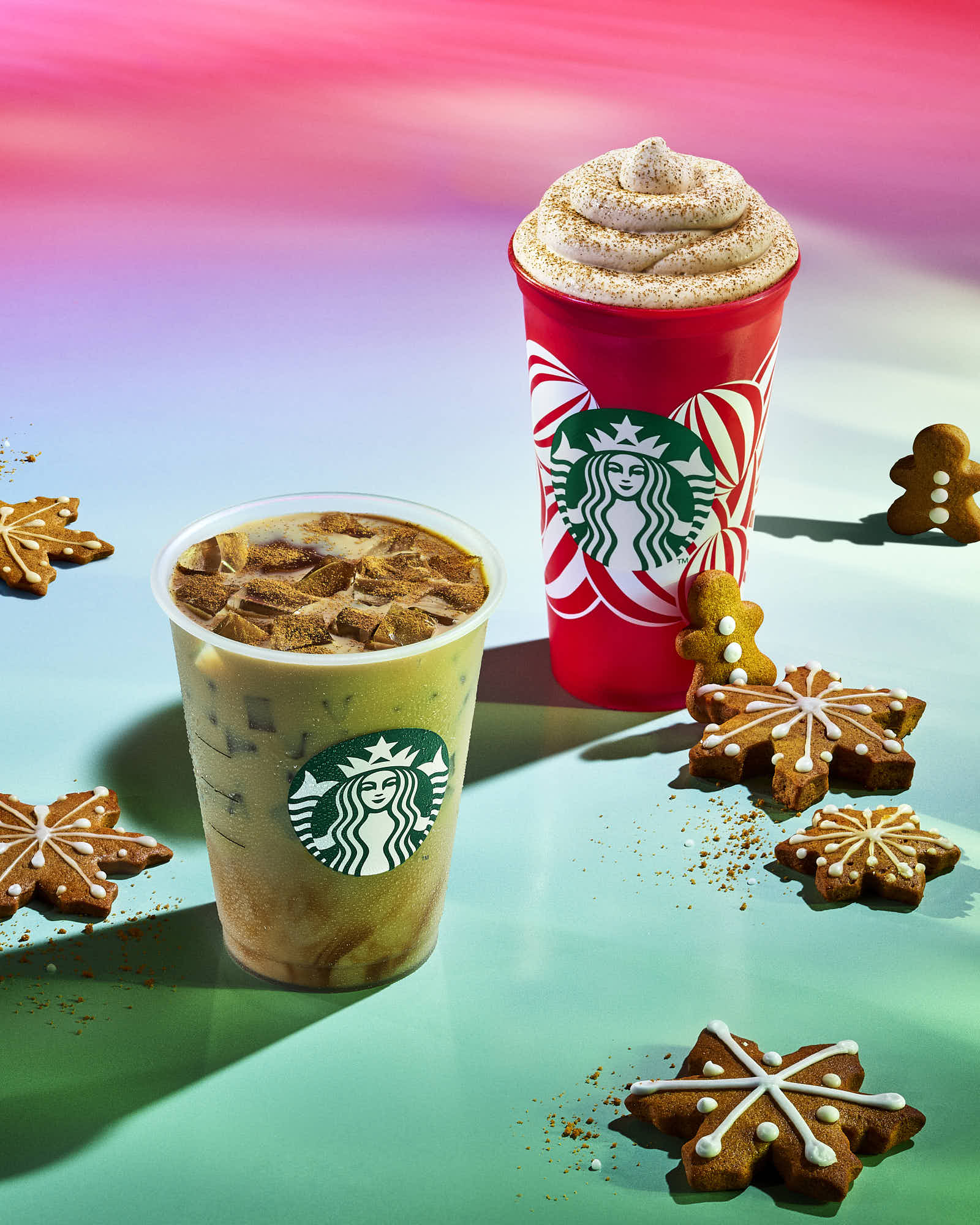 Two Starbucks drinks are displayed: a red and a green cup with festive decorations, against a colorful background.