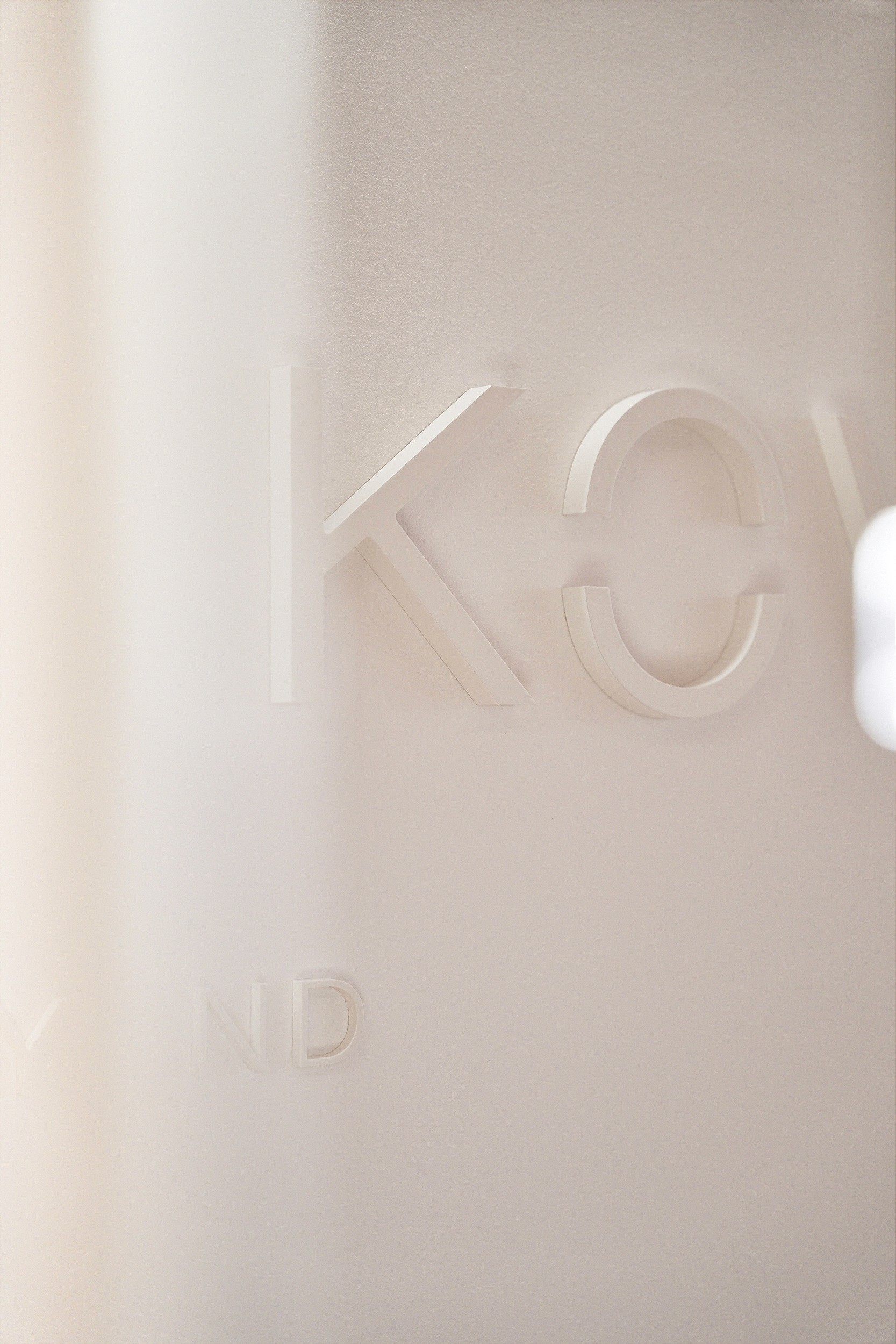 Ausgestanzte Buchstaben KO aus einem cremefarbenen Material