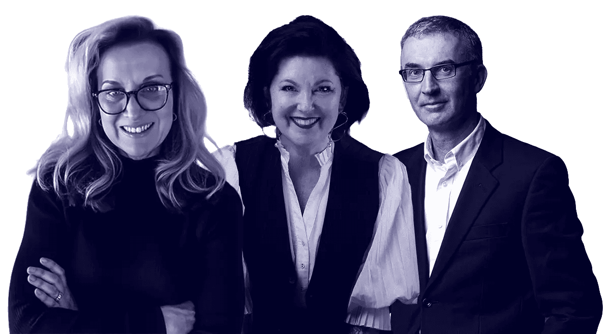 A group of three people poses in front of a white backdrop, all looking towards the viewer with friendly expressions.