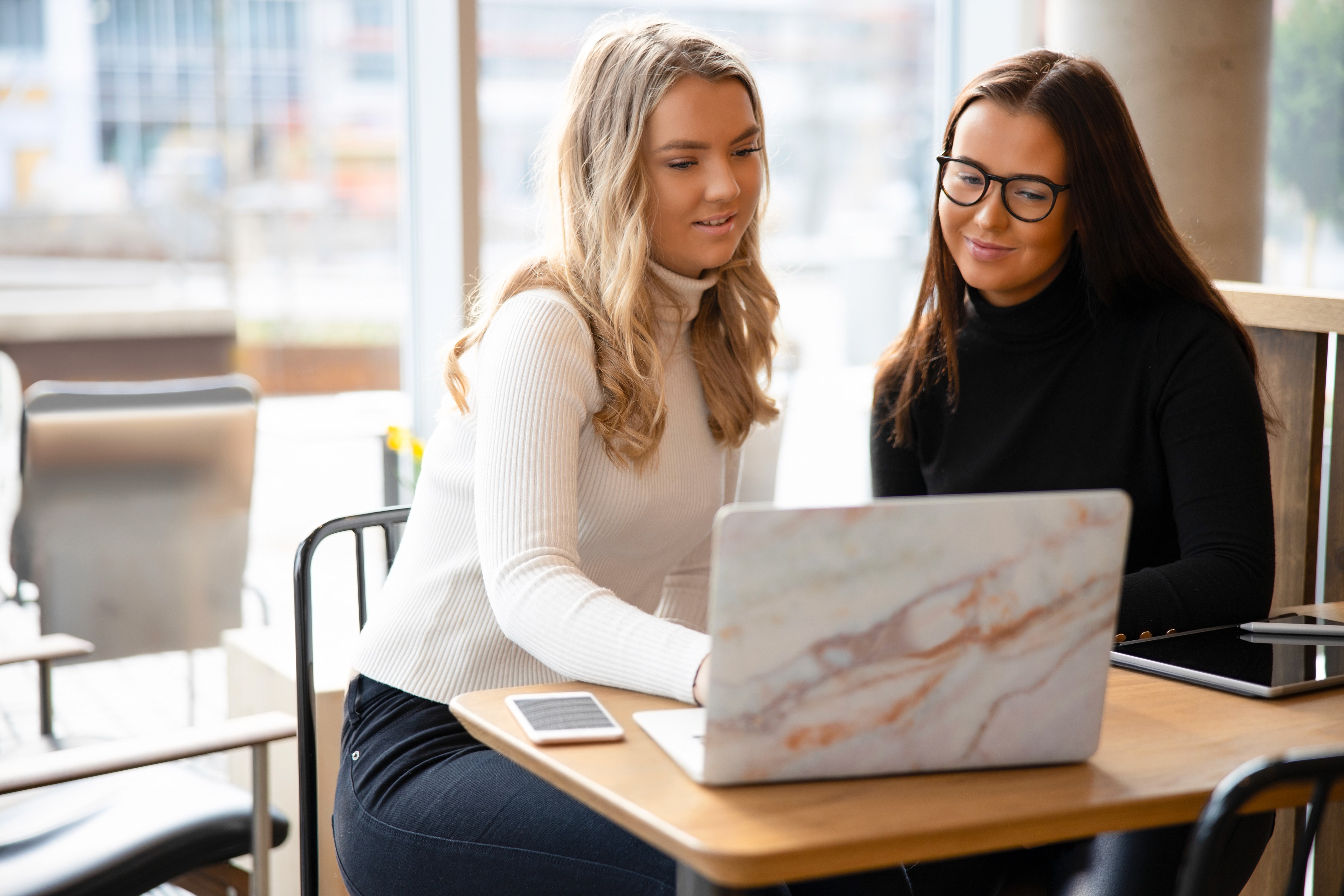 Two professionals reviewing a website on a laptop in a bright workspace, representing a collaborative Dublin web design company focused on strategy, clarity, and conversion.