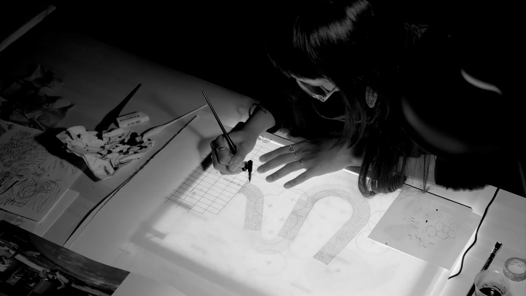 Landscape designer, Candice Teok, Director of The Garden Practice hand-drawing detailed planting texture on a light box, black and white process photo
