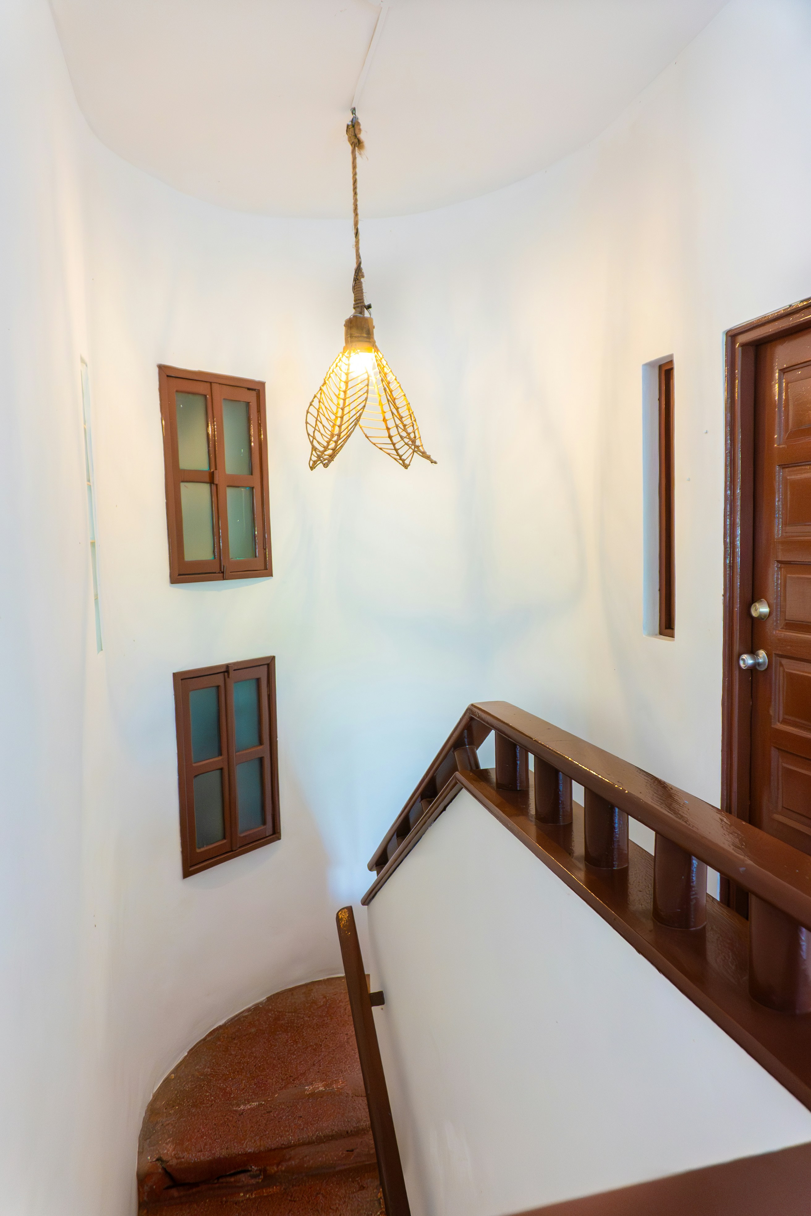 Wooden staircase with hanging lamp and windows