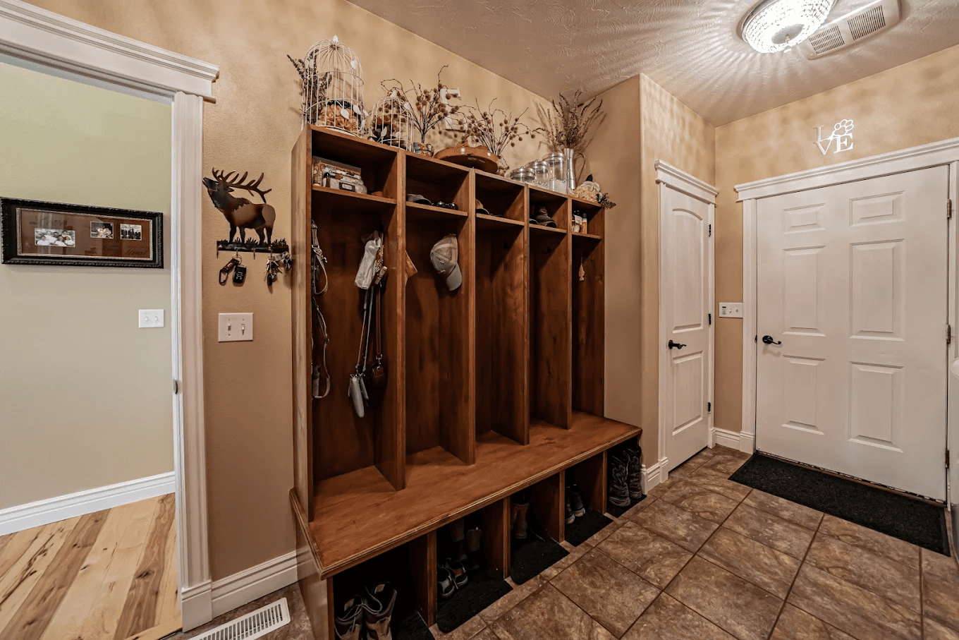 Wooden cubby bench with coats and hats.