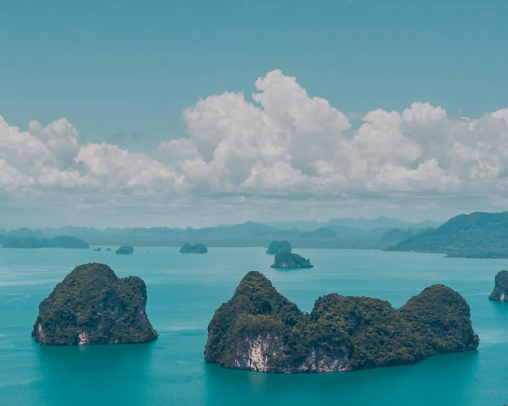 A boat traveling down a river next to a city