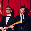 Two men in suits with a guitar