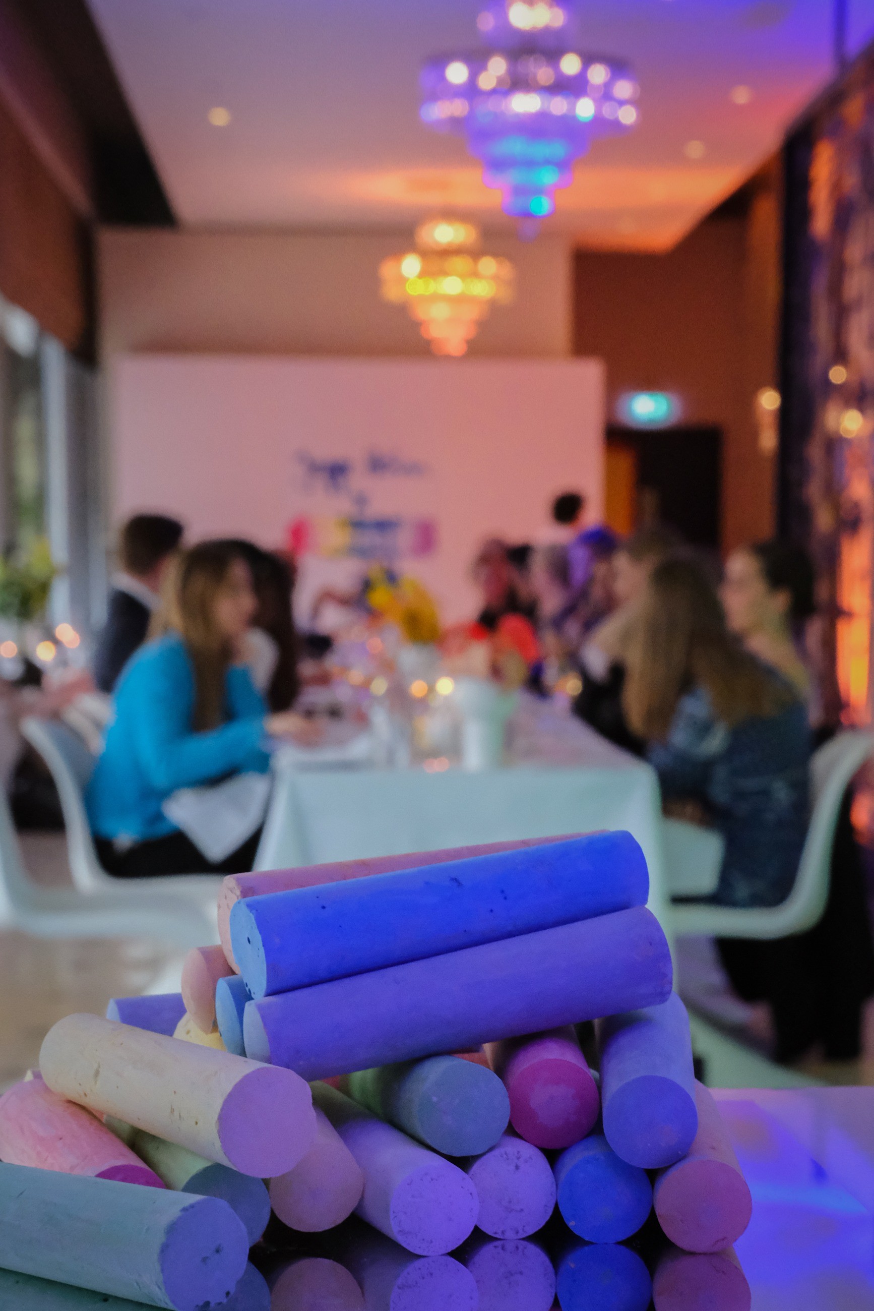 Colourful chalk in the foreground of the dinner setting
