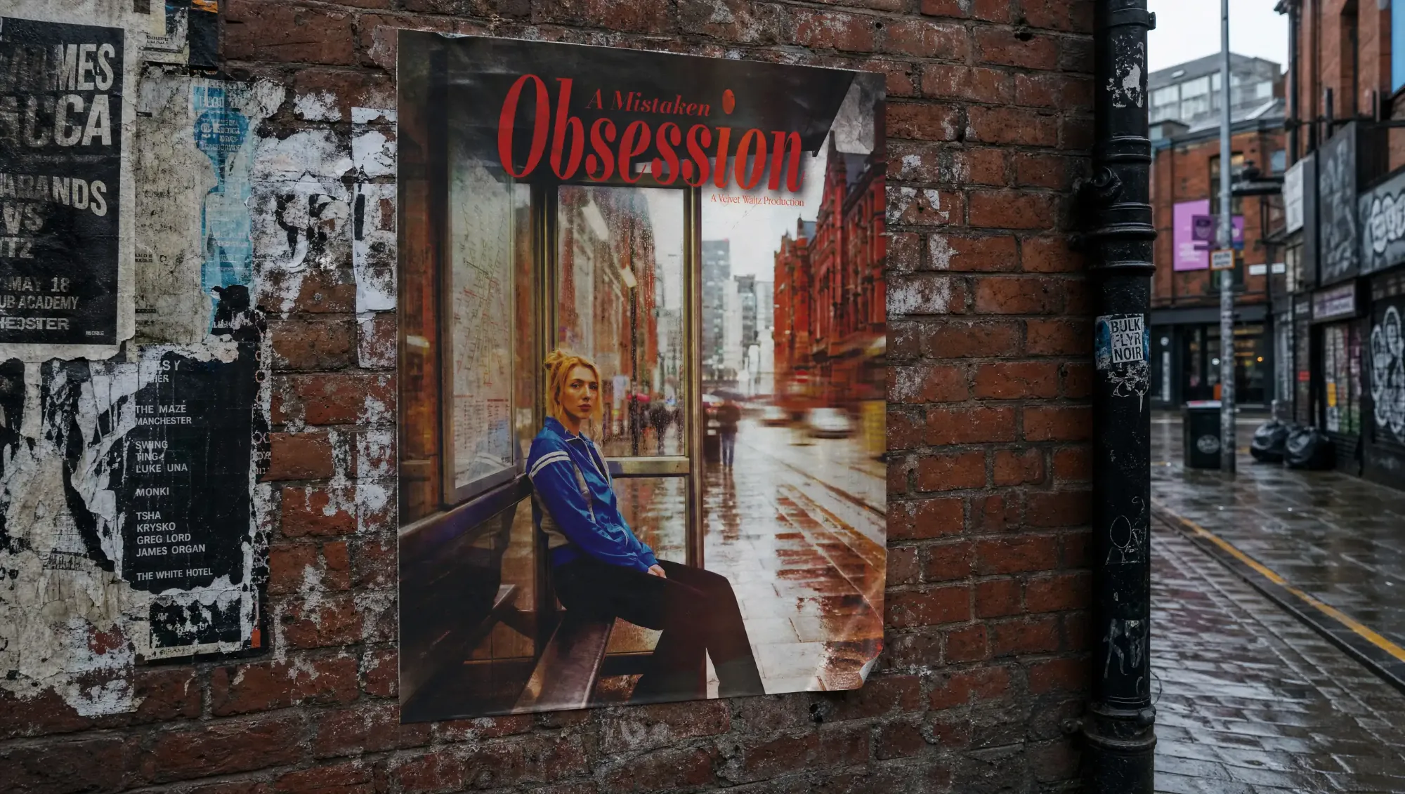 A Mistaken Obsession poster on a weathered brick wall in a rainy city street