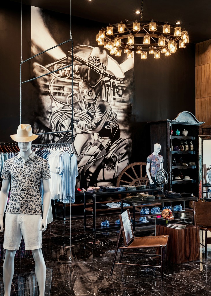 Couple standing on a balcony with binoculars in hand looking out over the ocean