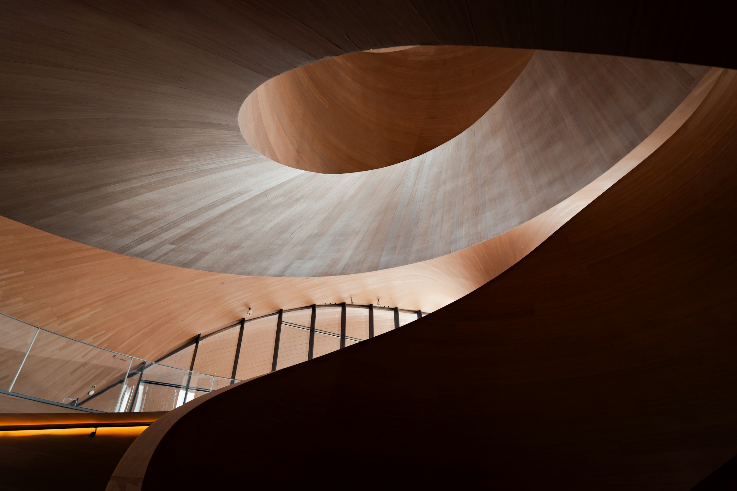 Modern wooden spiral staircase with dramatic lighting