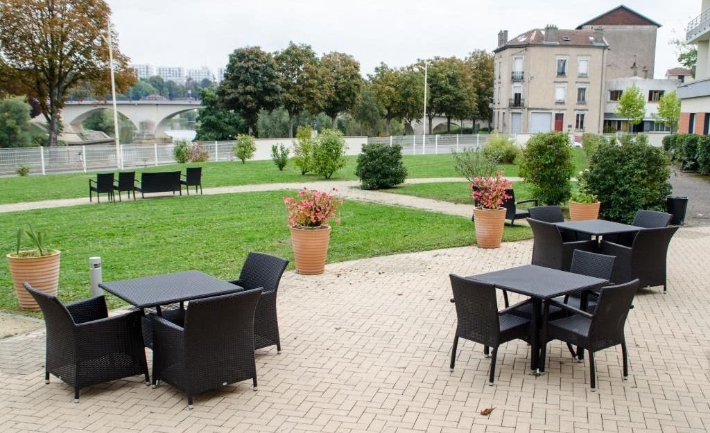 Outdoor terrace with patio furniture umbrellas flower planters and covered seating area