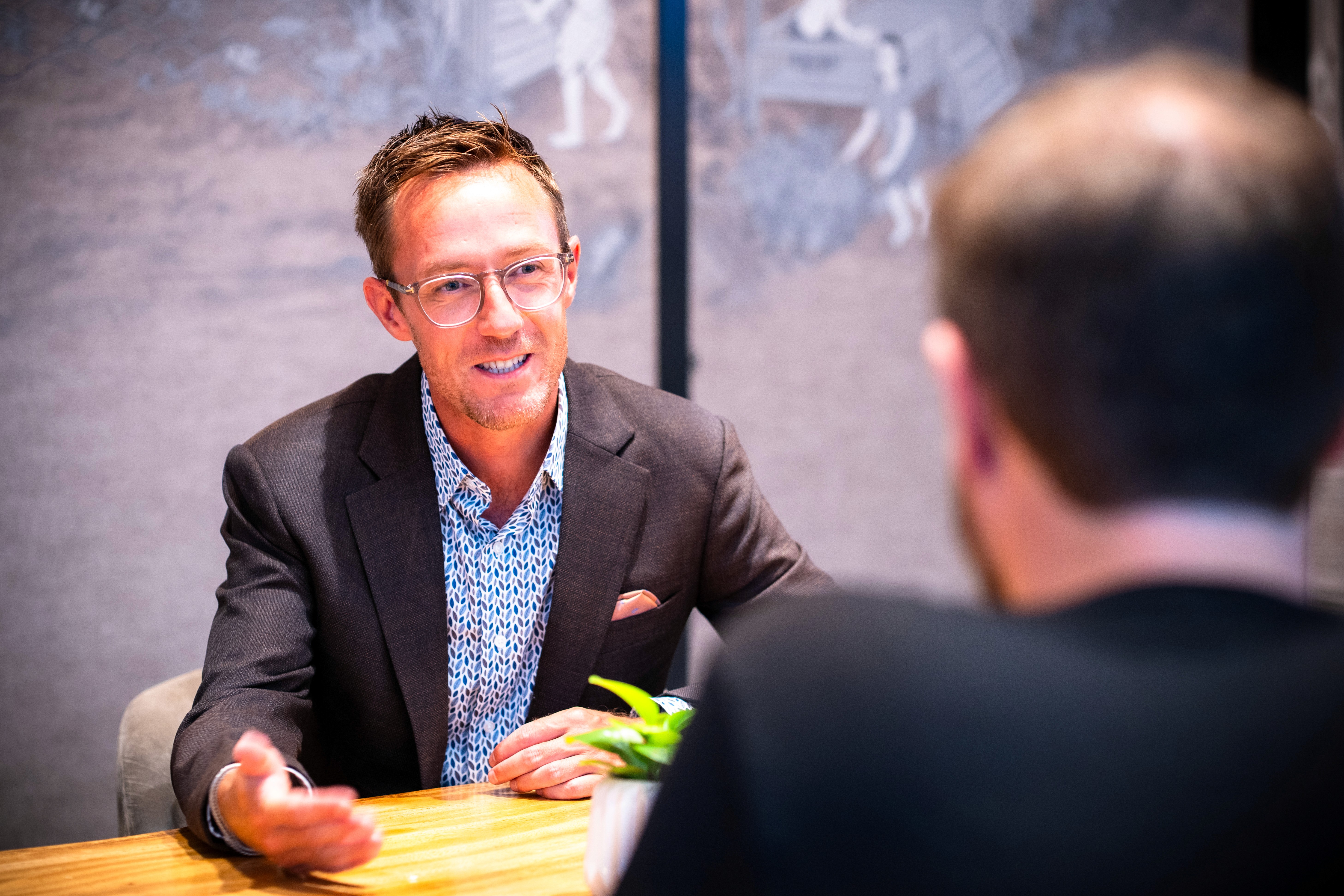 Founder and executive advisor in a focused leadership discussion at a table