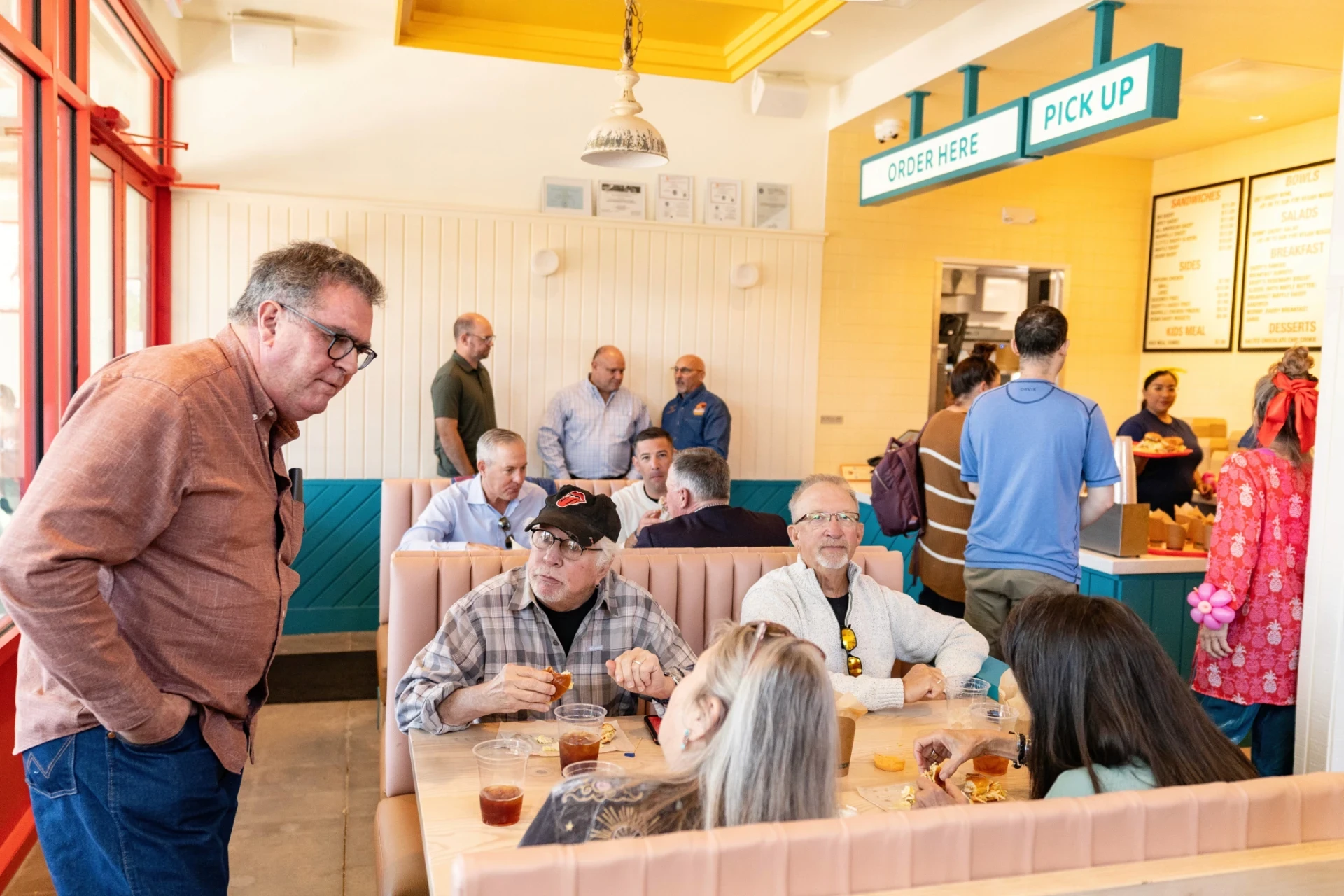 Guests seated inside Daddy’s Chicken Shack during an opening celebration