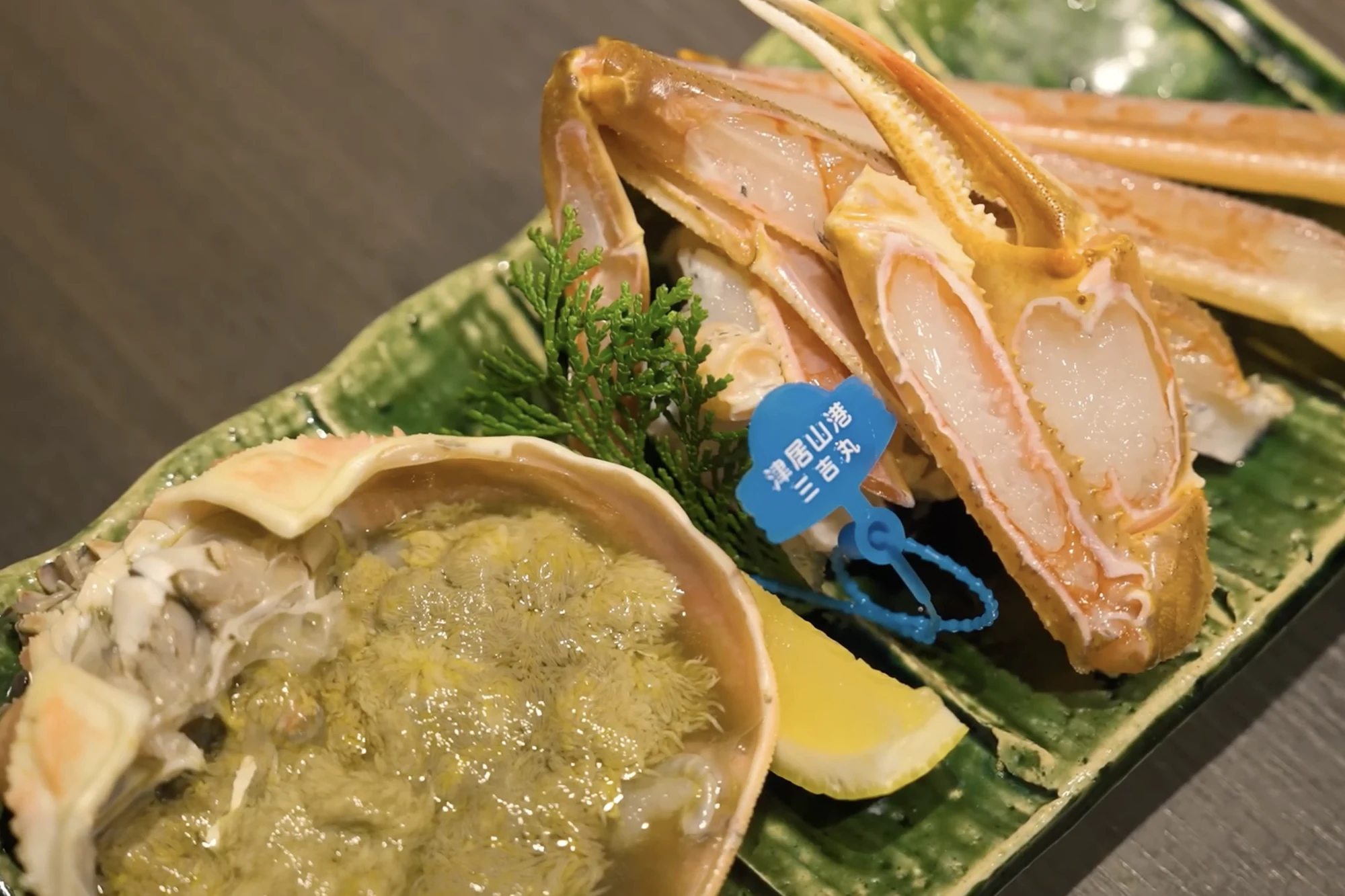 Snow crab on a plate in a Kinosaki inn with a blue provenance tag attached.
