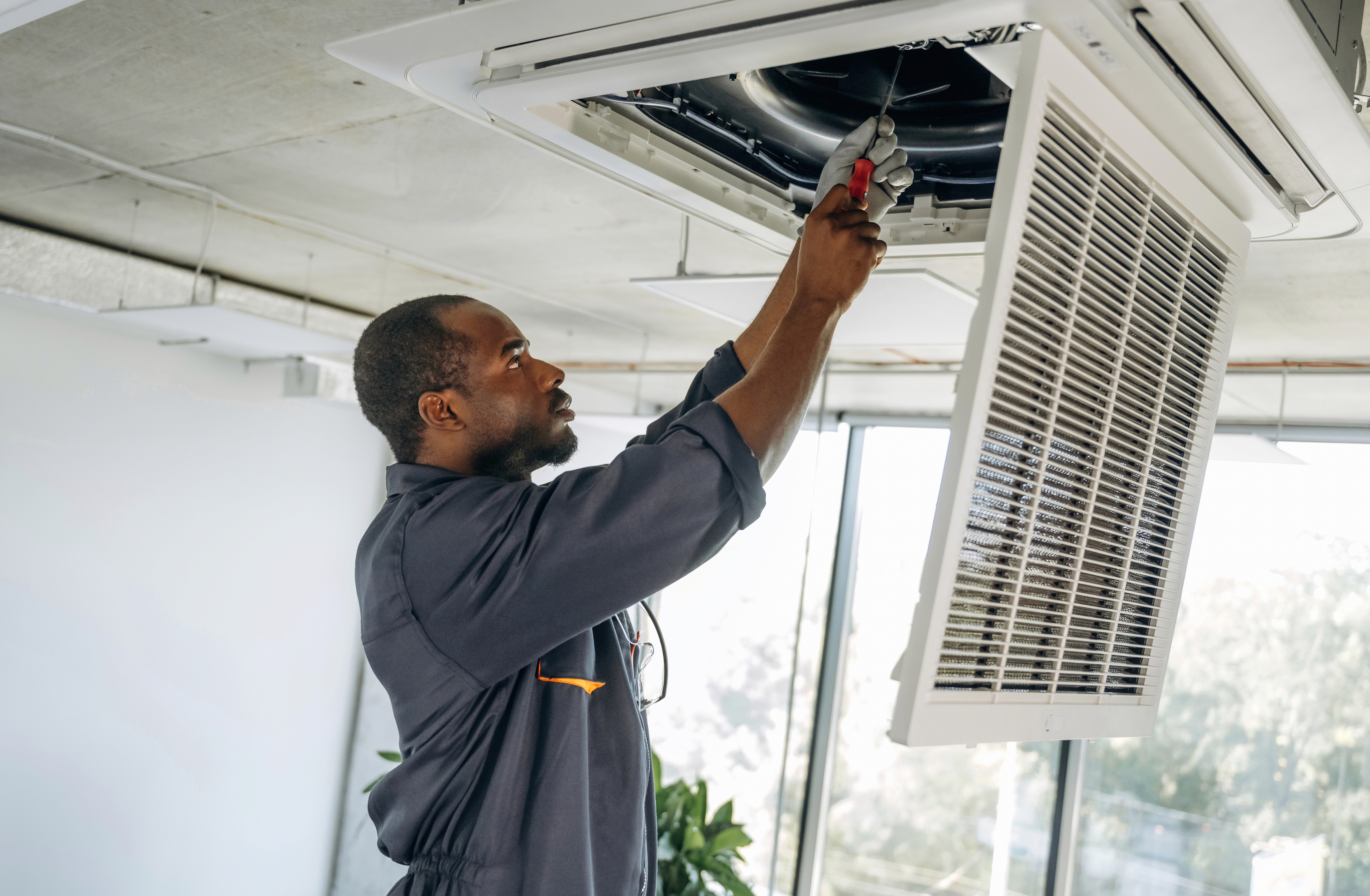 Commercial HVAC technician servicing an HVAC system inside a Toronto building