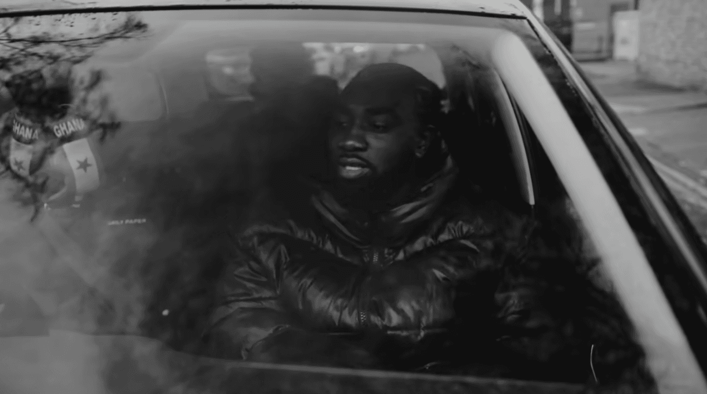 Man wearing an oversized green outfit with cartoon graphic