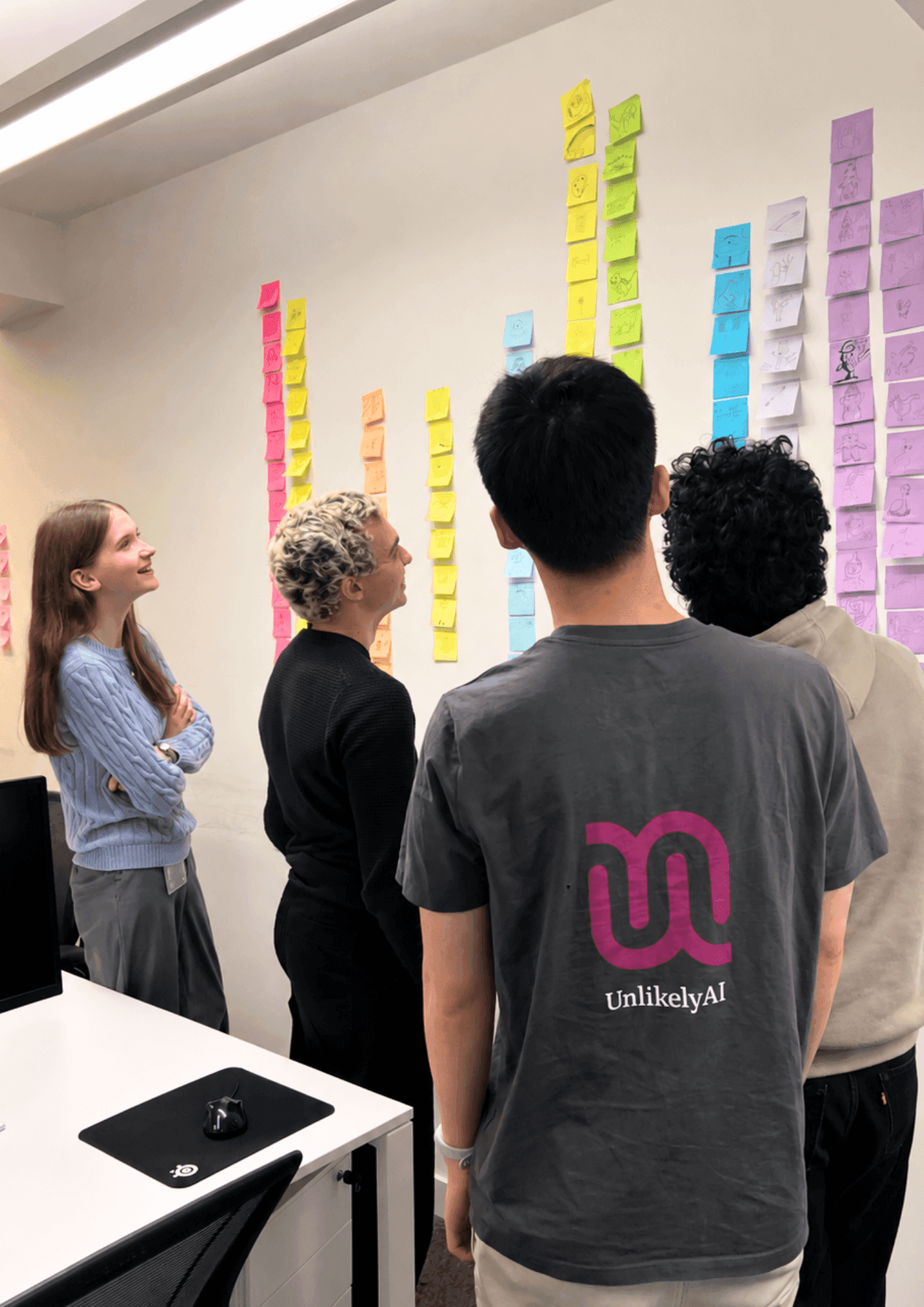 The interns looking at a wall of colourful sticky notes