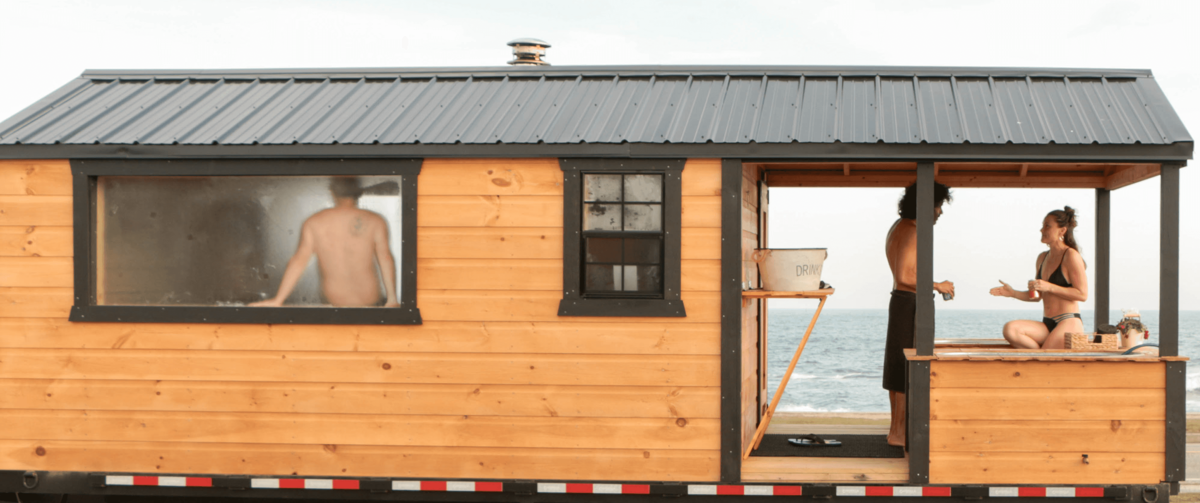 Wood-fired mobile sauna trailer with outdoor cold plunge tubs used for private wellness sessions in Newport County, Rhode Island.