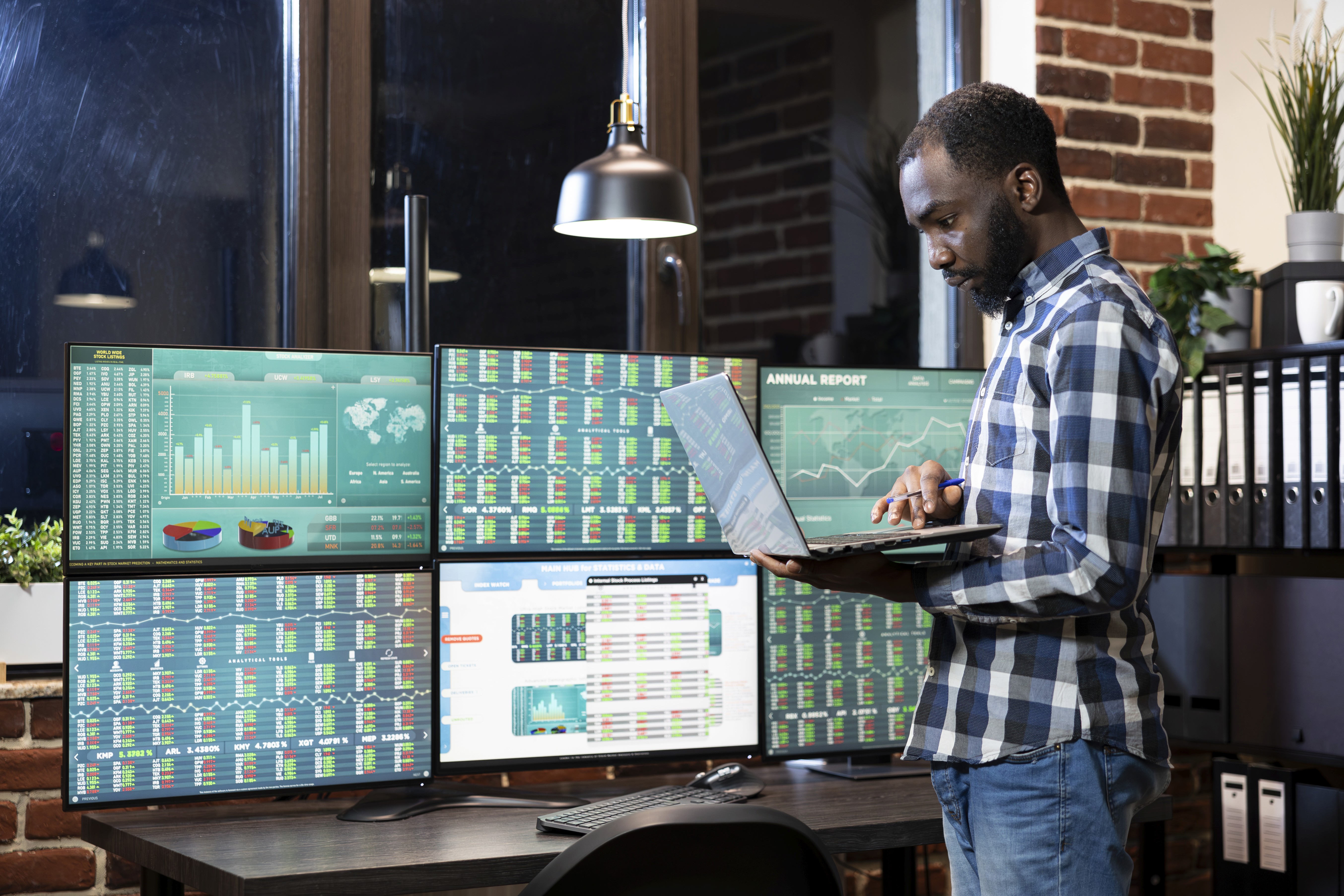 man standing in front of people sitting beside table with laptop computers