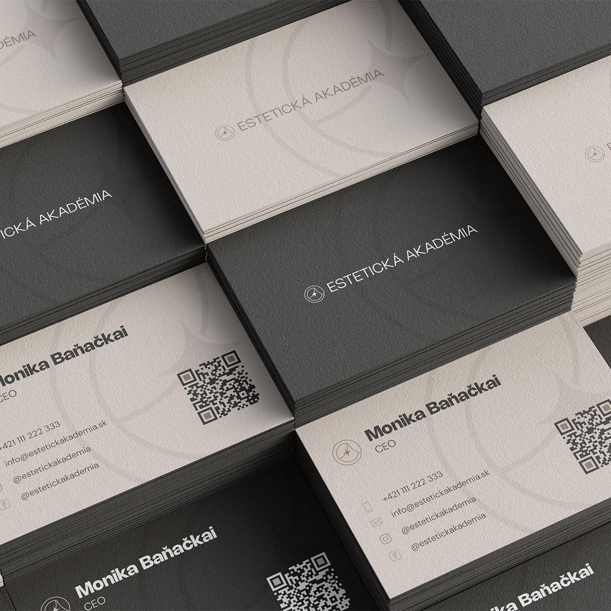 A close-up view of multiple square boxes in varying shades of black and gray, with minimalist text on the surfaces.