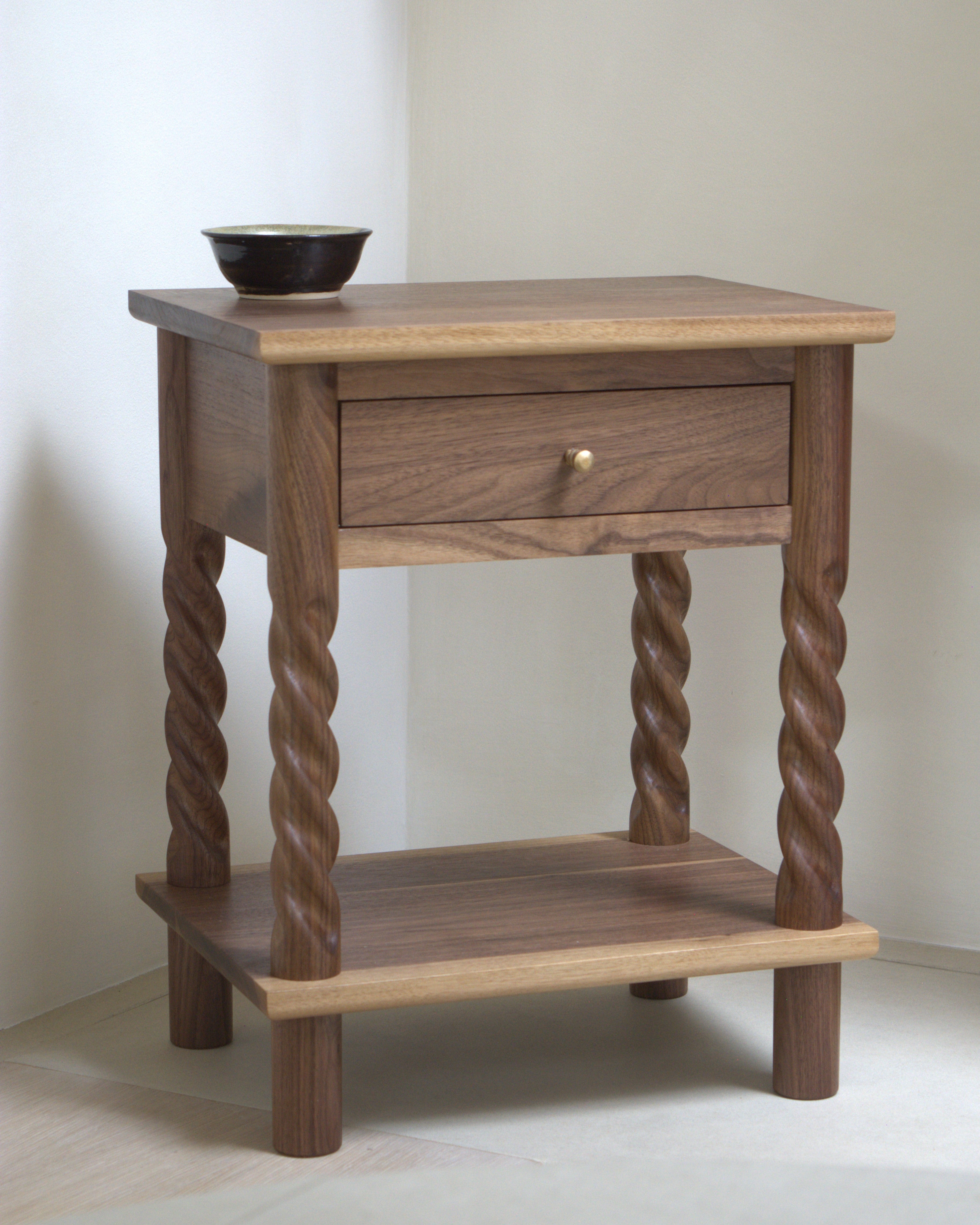 99 Bedside Table in walnut with a drawer against plaster wall