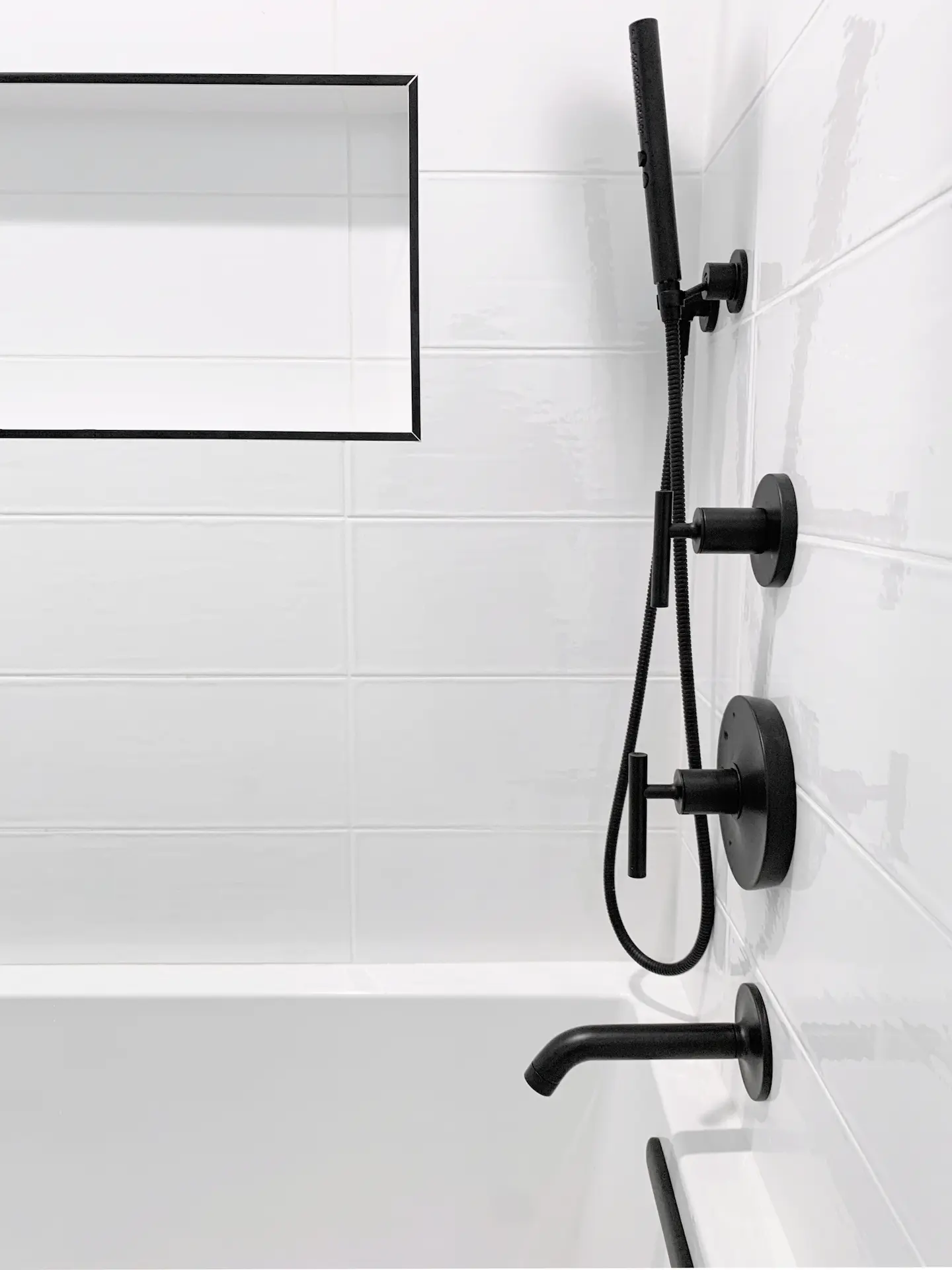 View of the shower fixtures in the kids' bathroom, showcasing modern black designs that add a touch of sophistication to the functional area. Photo by Todd Huge.