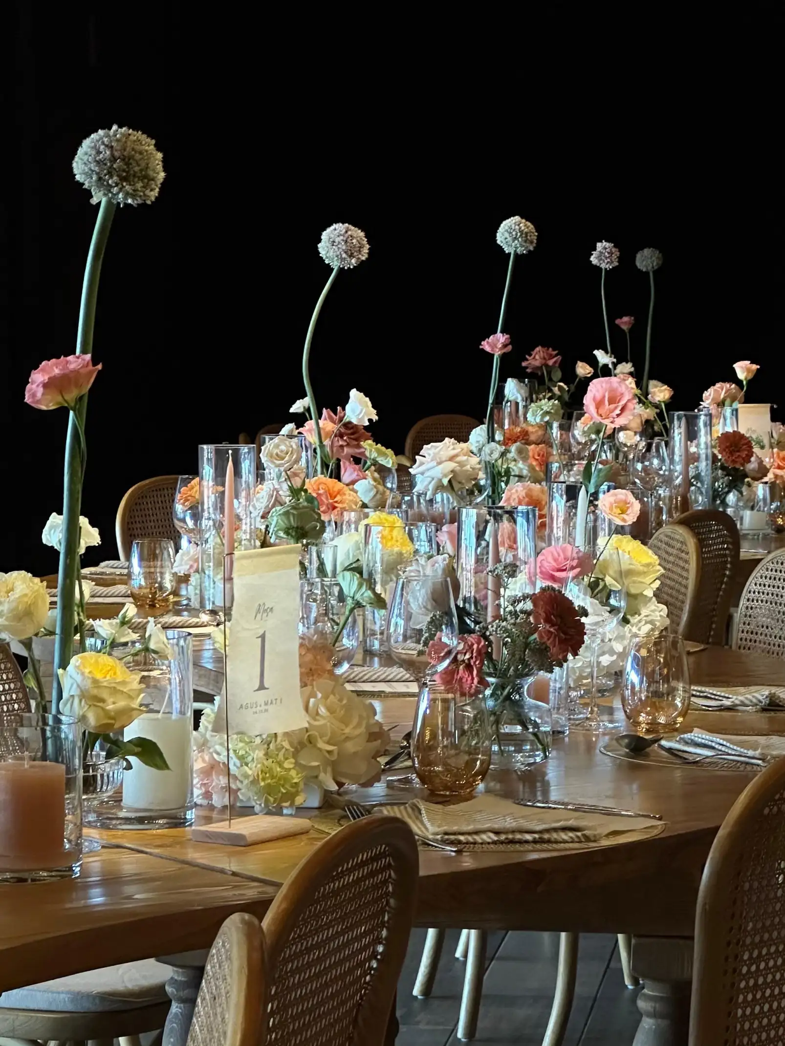 Composición de mesas con flores altas y velas, creando una estética romántica y sofisticada.
