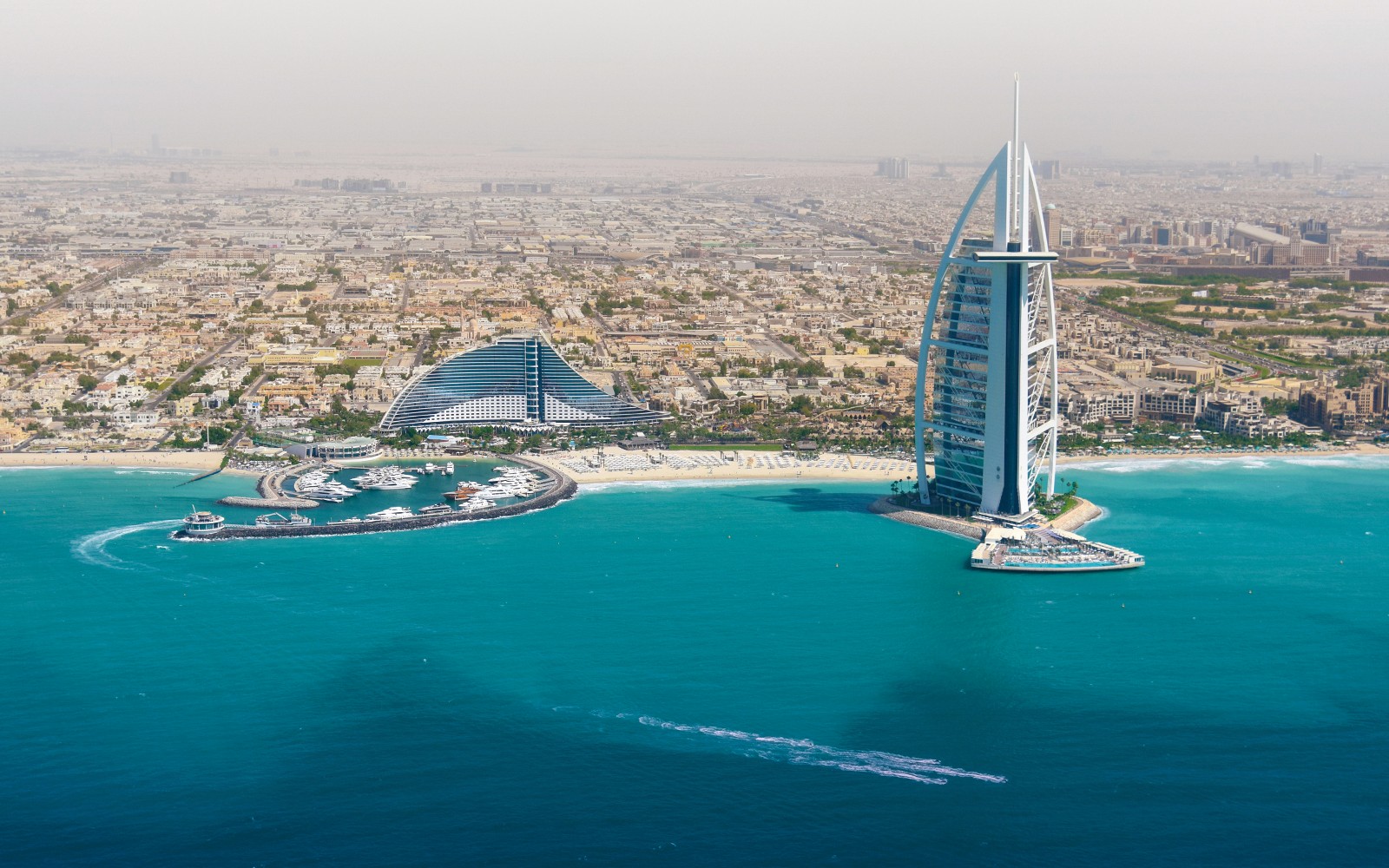 从直升机视角俯瞰迪拜天际线,伯瓷酒店与海岸线尽收眼底。