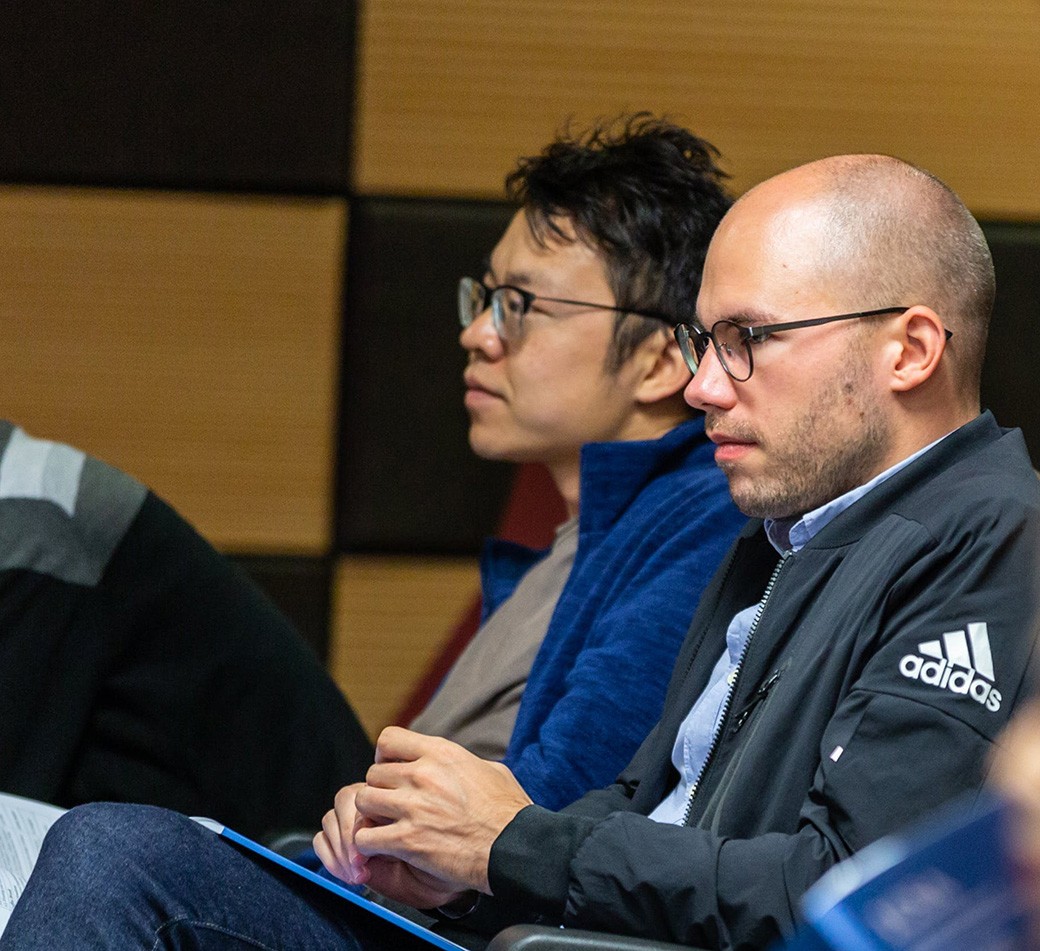 Two men sit in a lecture hall