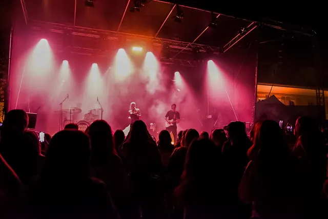 Publikum und rot beleuchtete Festivalbühne am Abend 2026