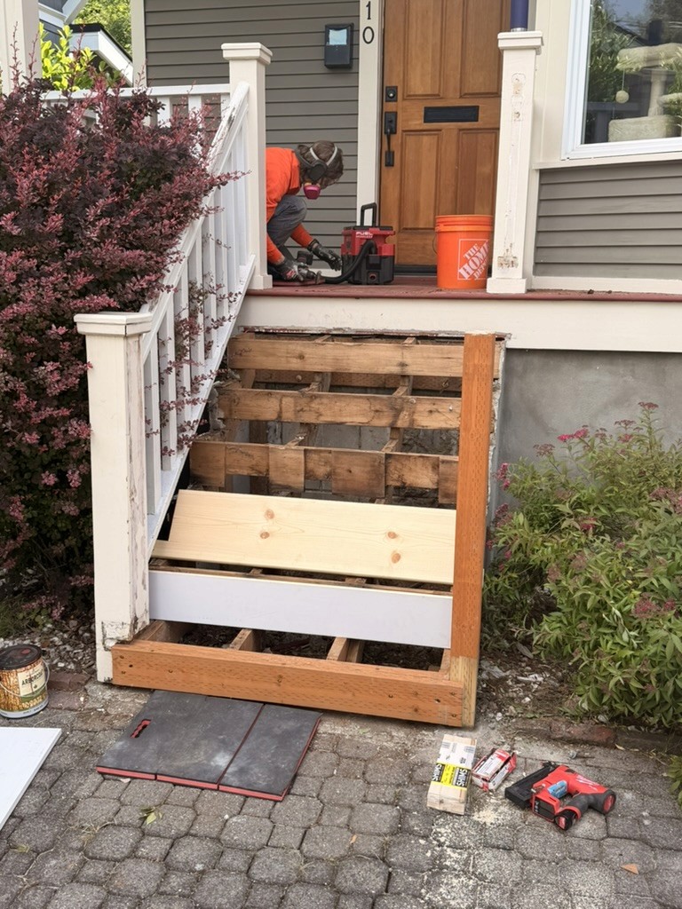Handyman repairing entry stairs of a seattle century home 
