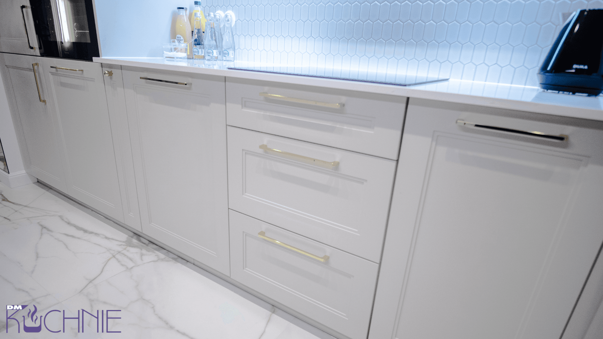 Kuchnia na wymiar Warszawa – jasne frezowane fronty szafek kuchennych, złote uchwyty i nowoczesne meble kuchenne