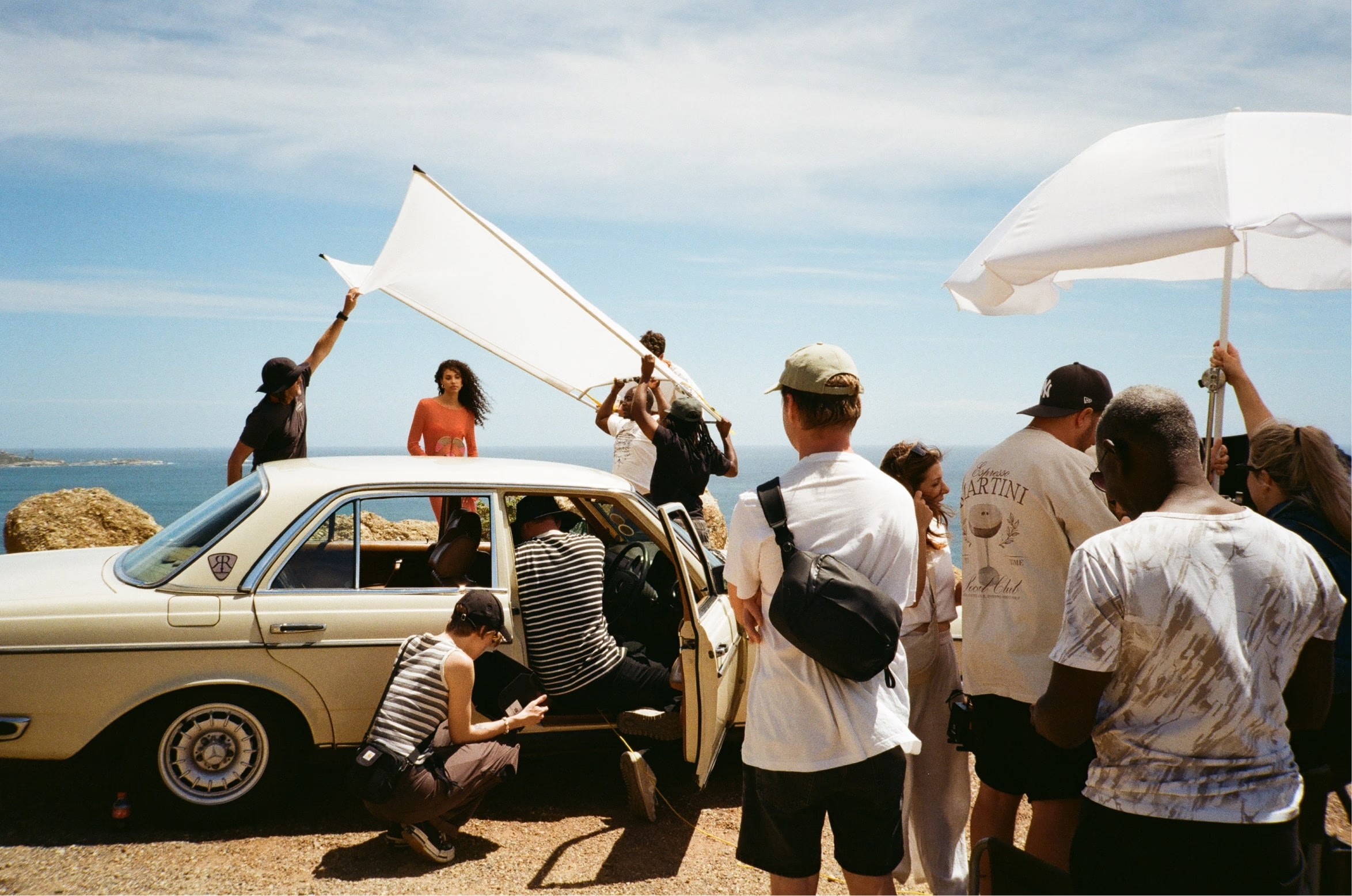 Fashion photoshoot behind a vintage car by the sea.