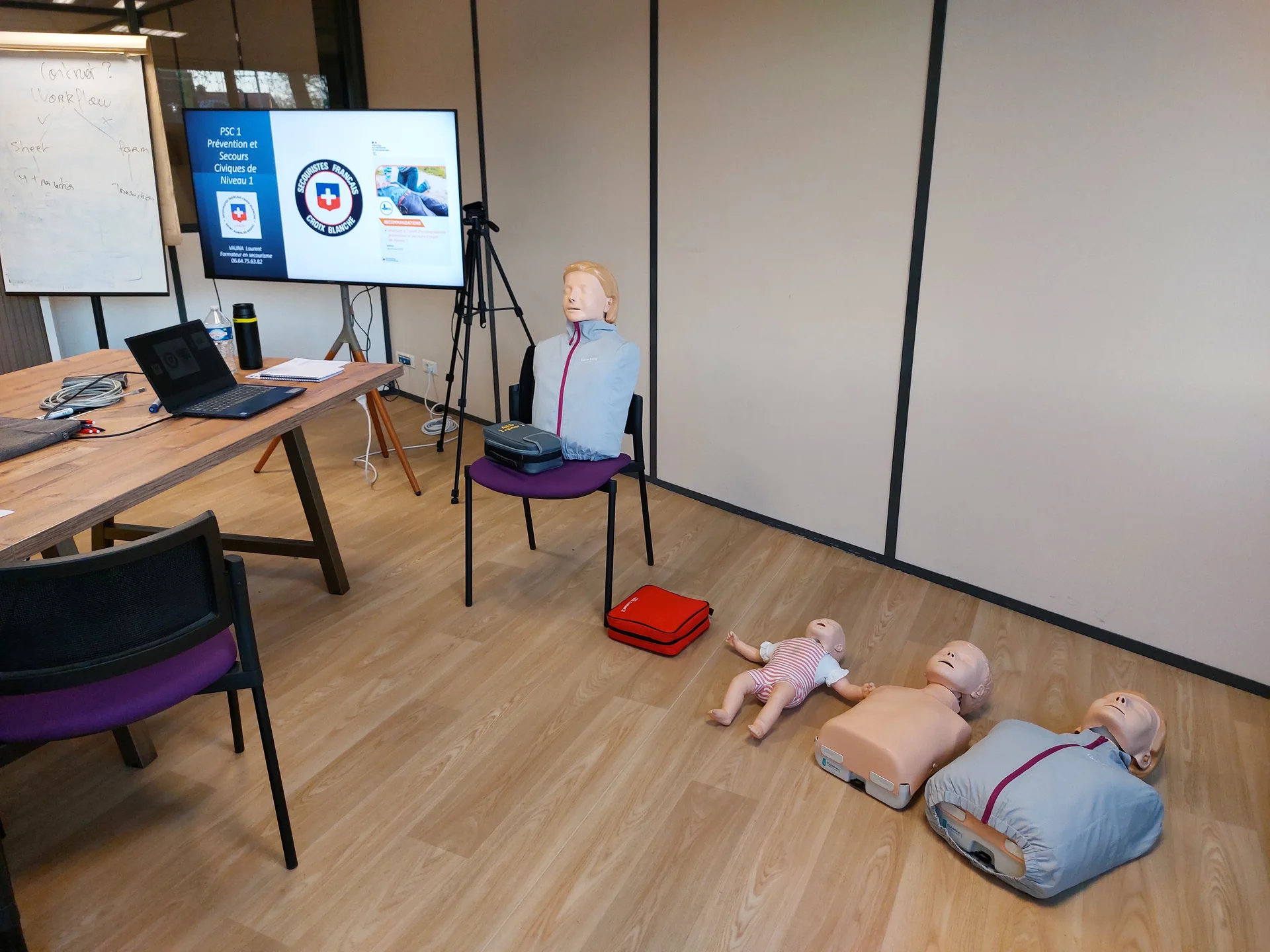 Salle de formation aux premiers secours avec mannequins de réanimation et matériel médical.