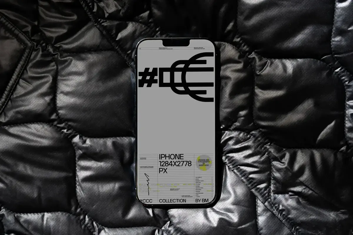 iPhone mockup showcasing a sleek monochrome UX/UI design with modular typography on a black quilted background.