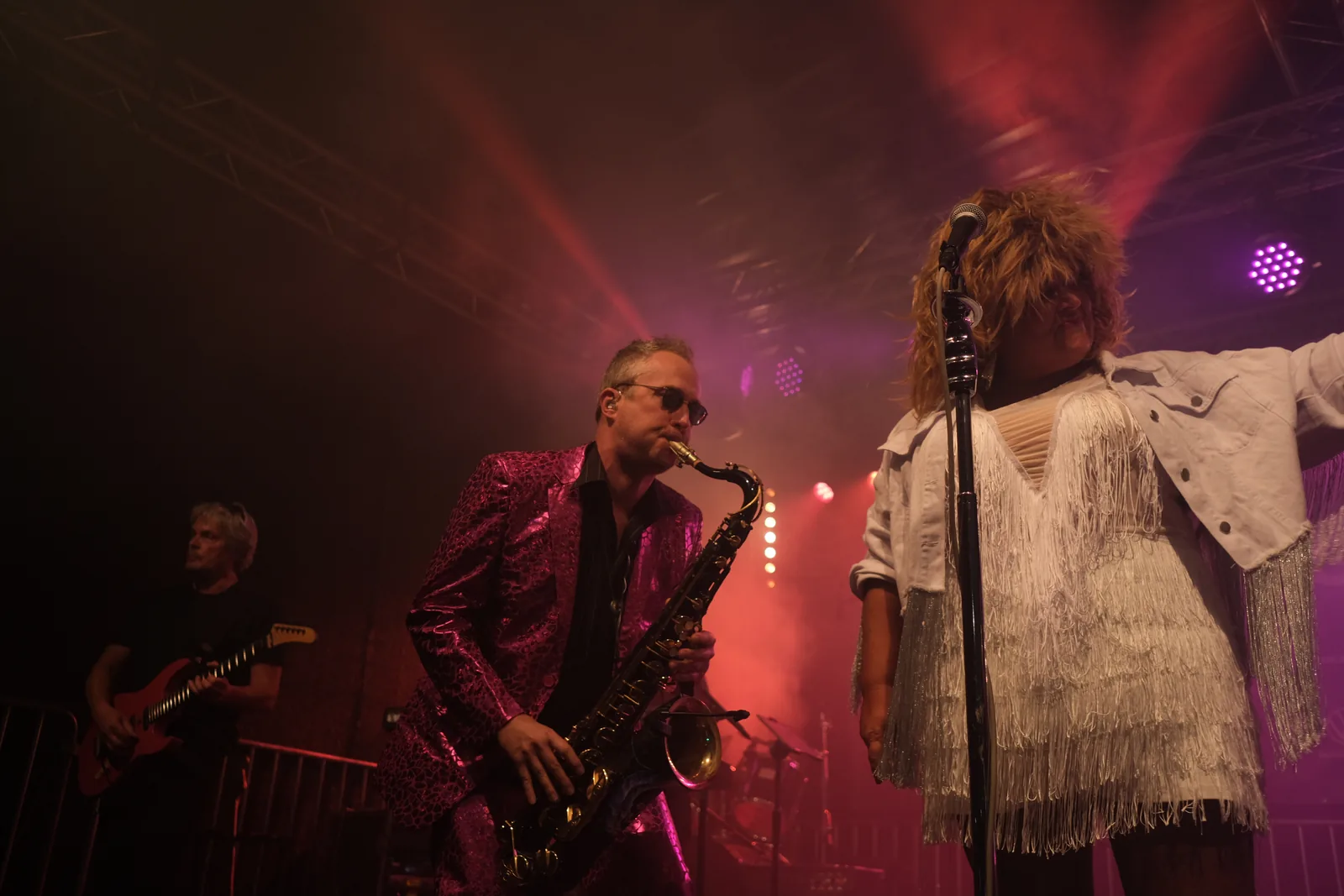Saxofonist im roten Bühnenlicht.