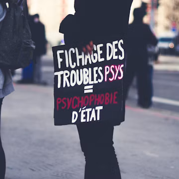 a woman holding a sign on the side of the road