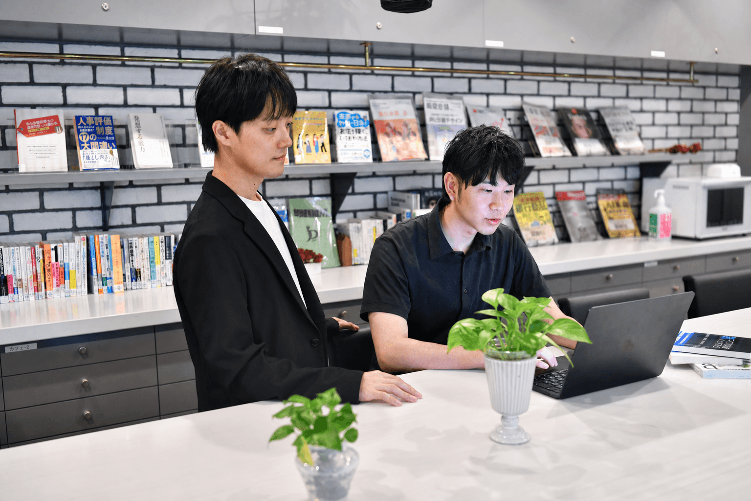 LeapWellメンバーがオフィスでノートPCを確認しながら働く様子