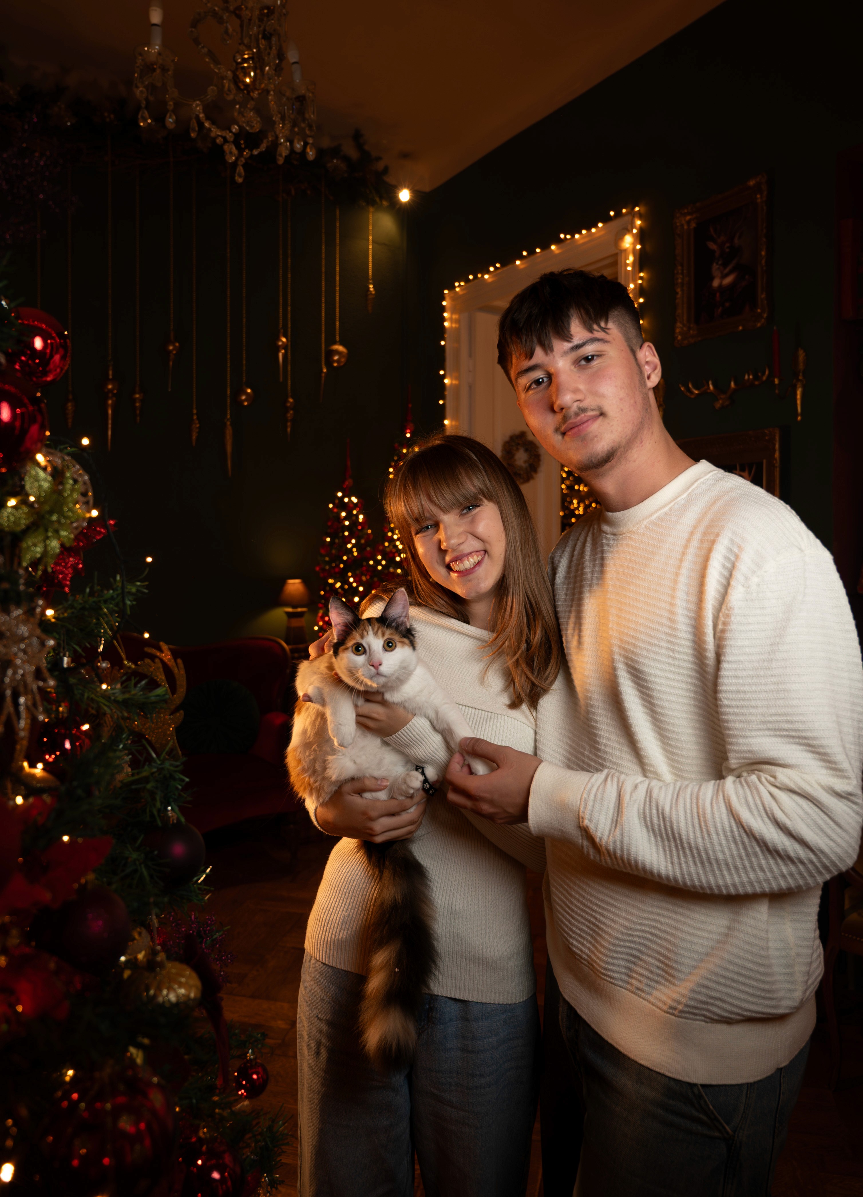 Ședință foto de Crăciun cu cuplu și pisică, decor festiv și lumină caldă, fotograf Crăciun București