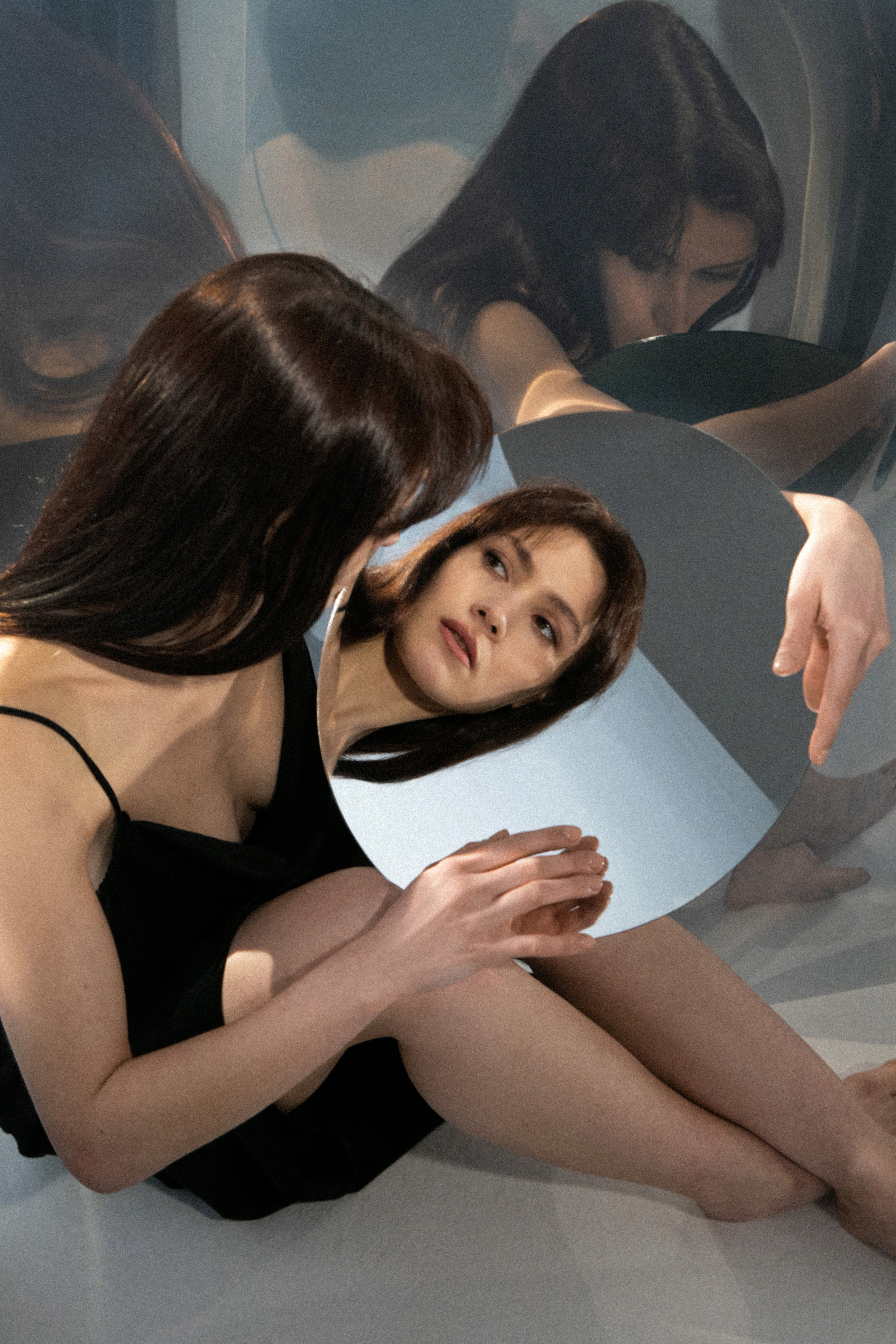 Young woman posing while looking at her reflection in a mirror.