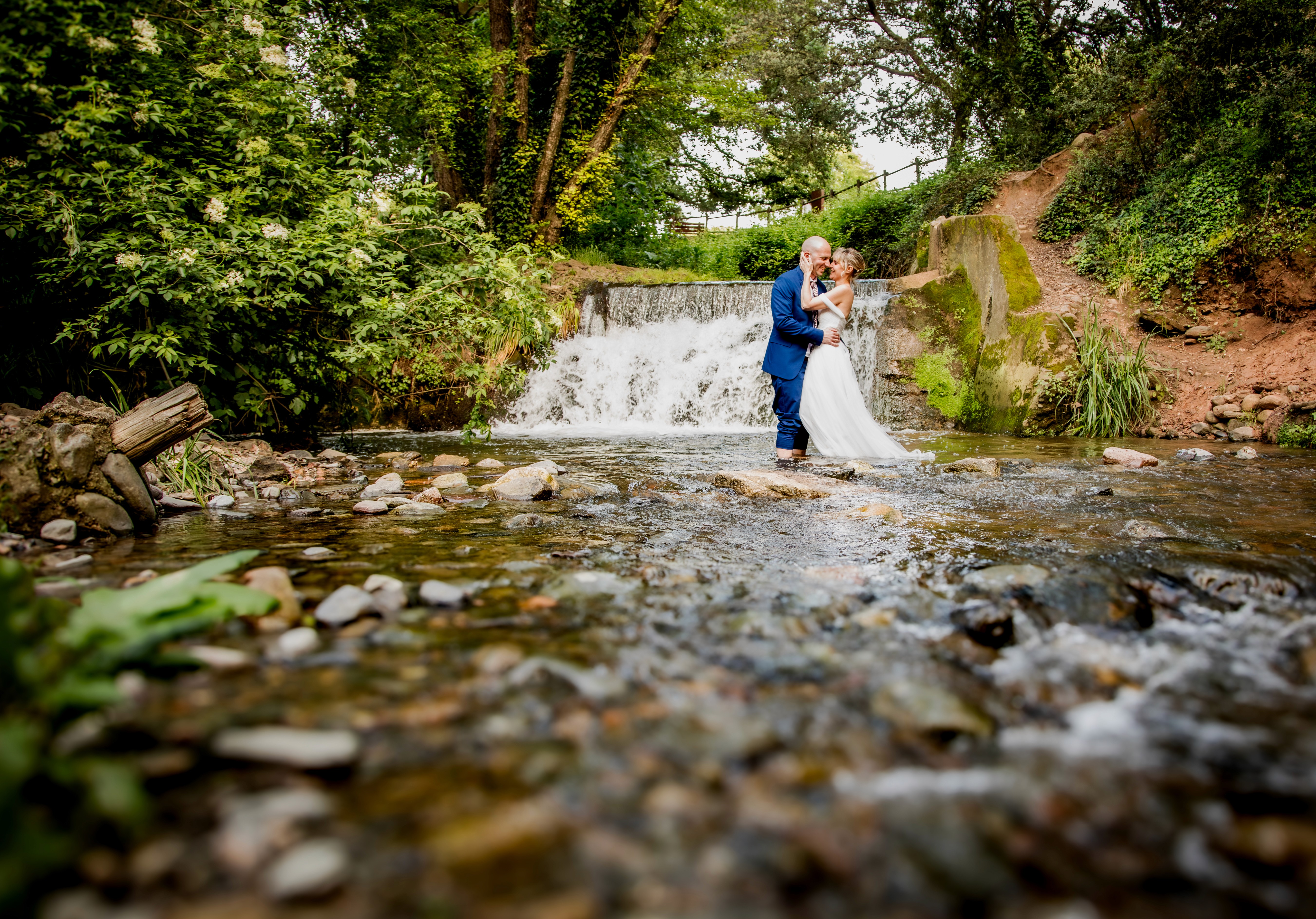 Sesión de boda donde la pareja se encuentra en medio del río.