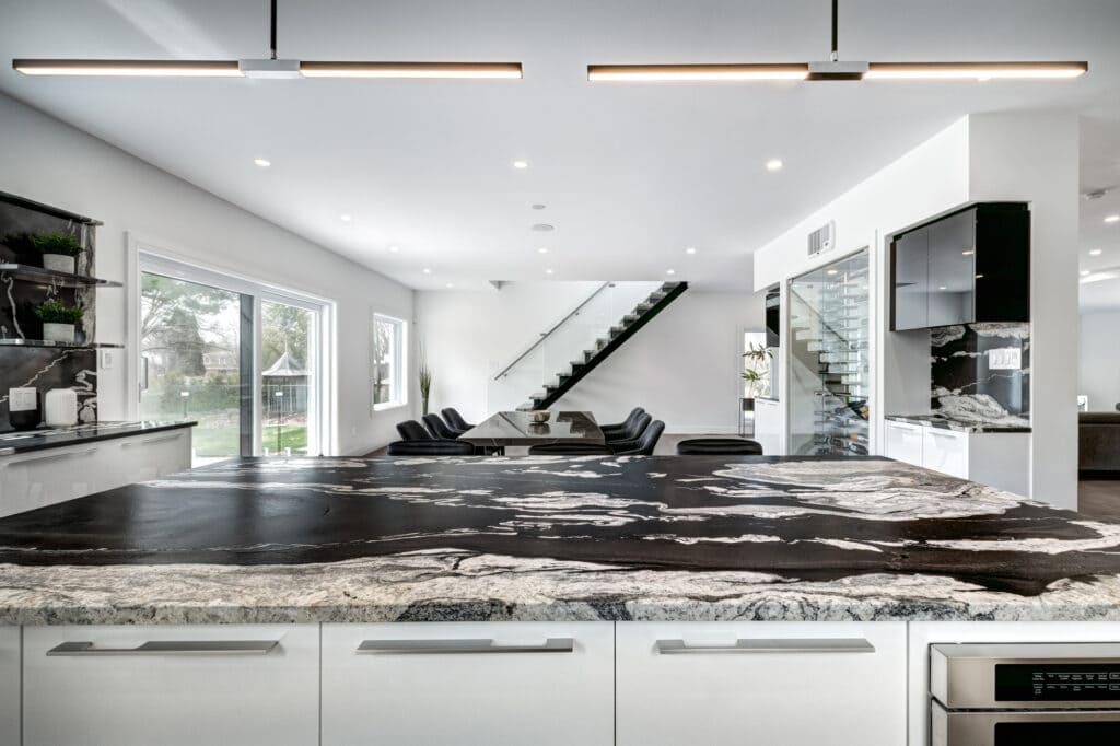 Elegant living room renovation featuring a white brick fireplace, custom built-in shelves, modern gray sofas, and a marble-top coffee table — a project by B&Y Reno Corp
