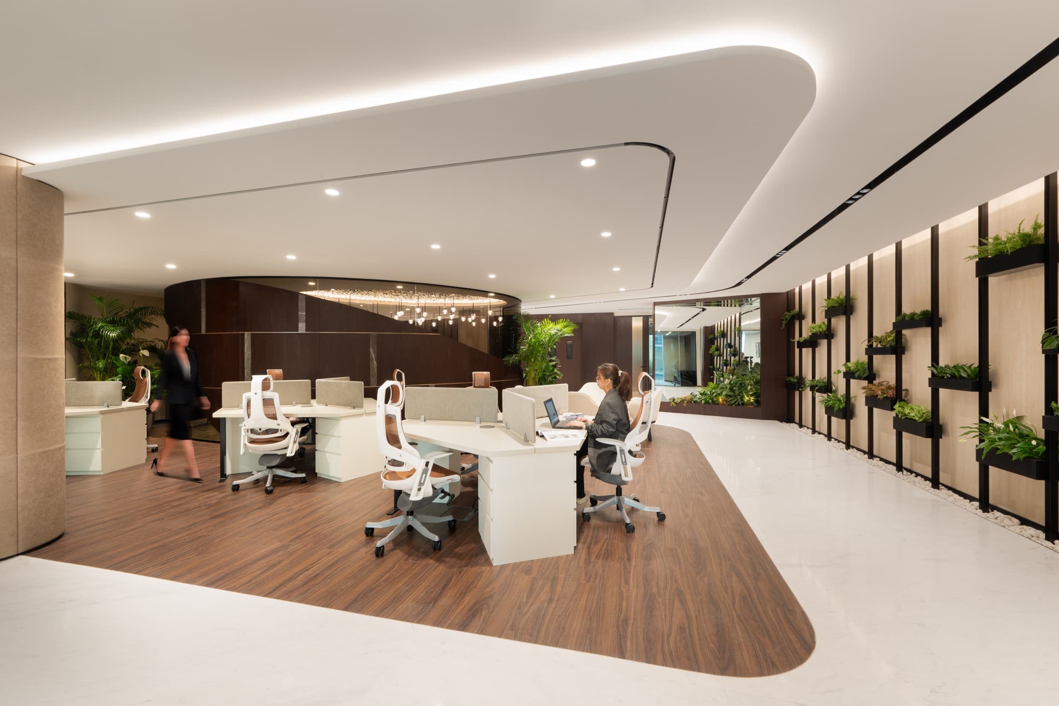 Open-plan coworking area in serviced office spaces in Dubai with stylish desks, ergonomic chairs, and natural greenery.