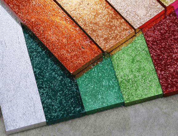 Electroplated stone tiles in various colors, arranged diagonally to display their textured surfaces and metallic finishes.