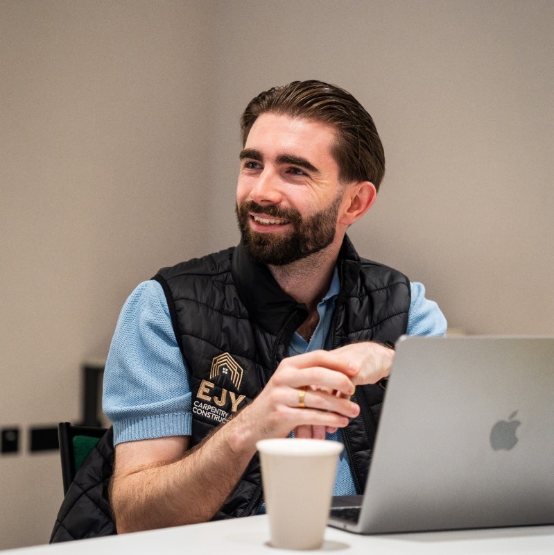 A man works on a laptop in an office.
