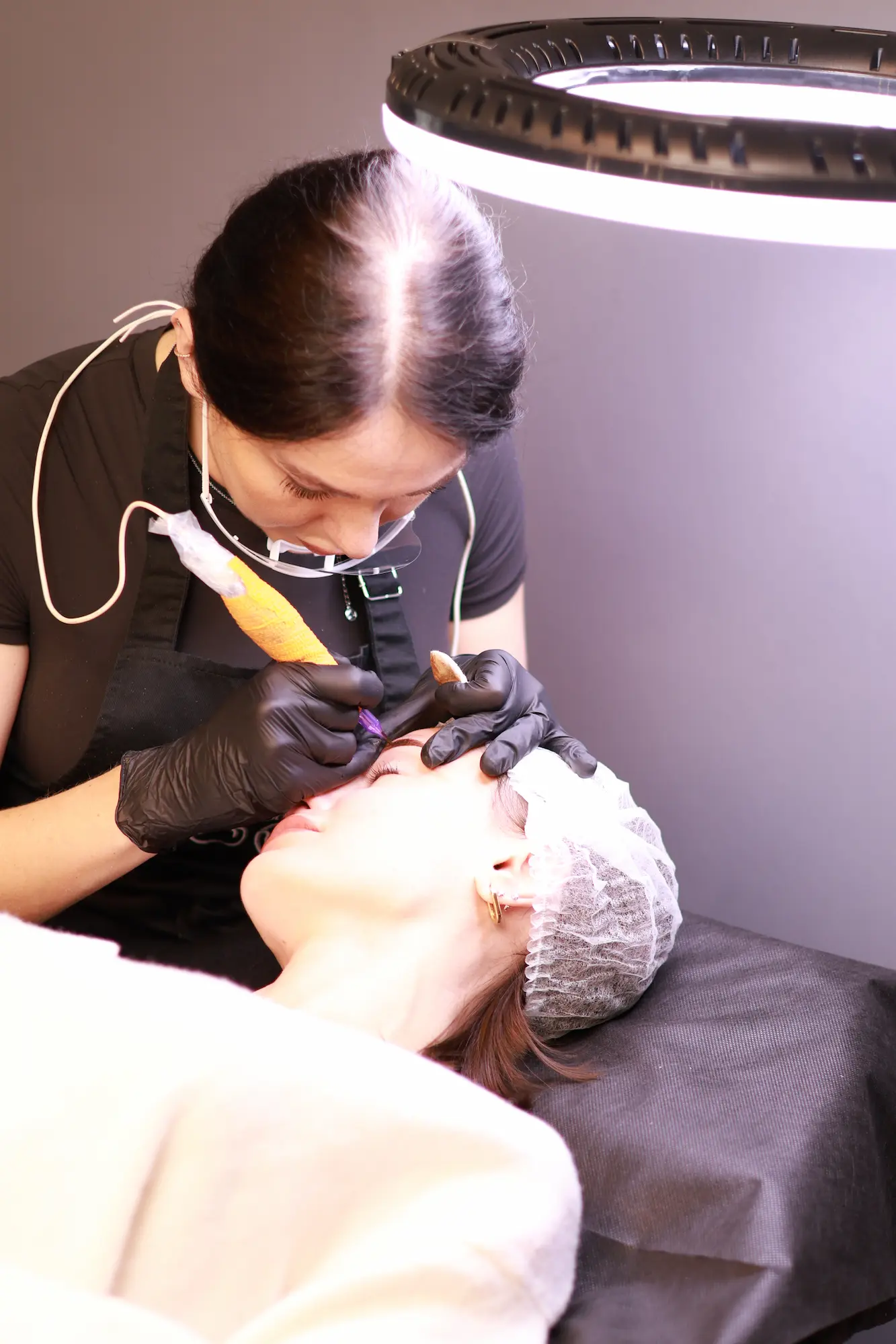 PMU artist using magnification equipment during treatment